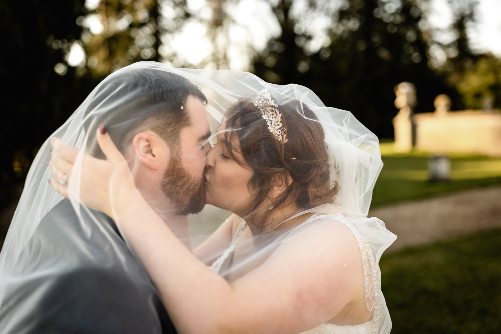 Close-up of the couple kissing beneath the bride's veil