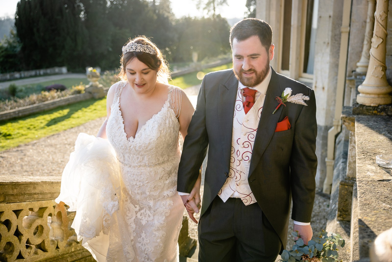 The couple walking the terrace at Orchardleigh House in golden evening light