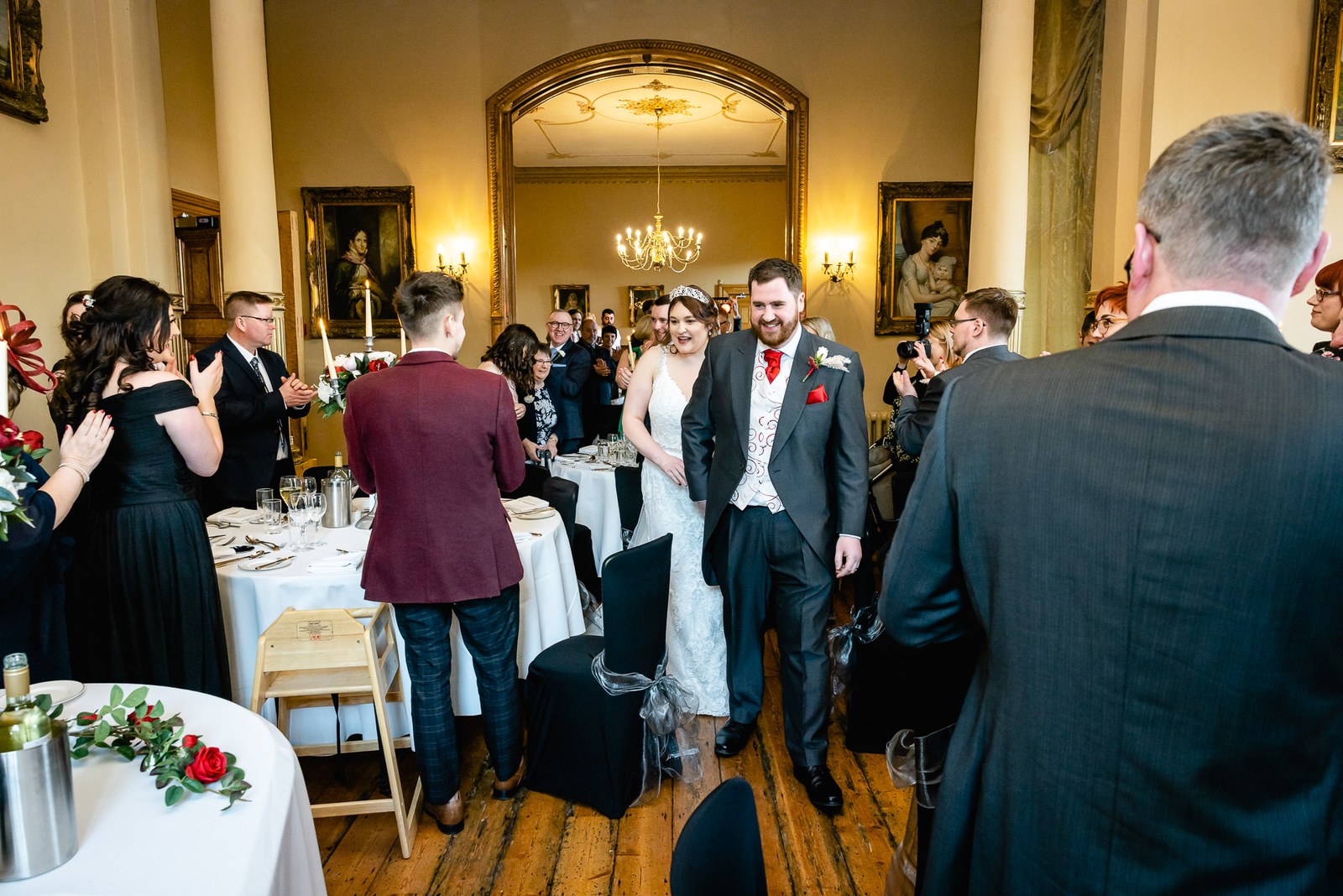 The newlyweds entering the dining room as guests applaud