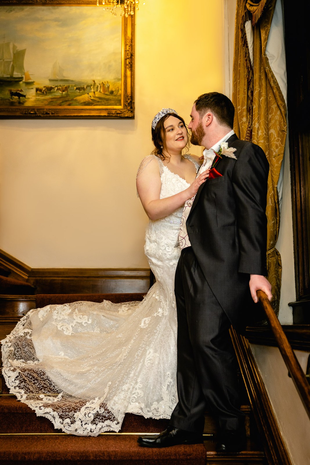 The couple on the grand staircase of Orchardleigh House, the bride's train cascading down the steps