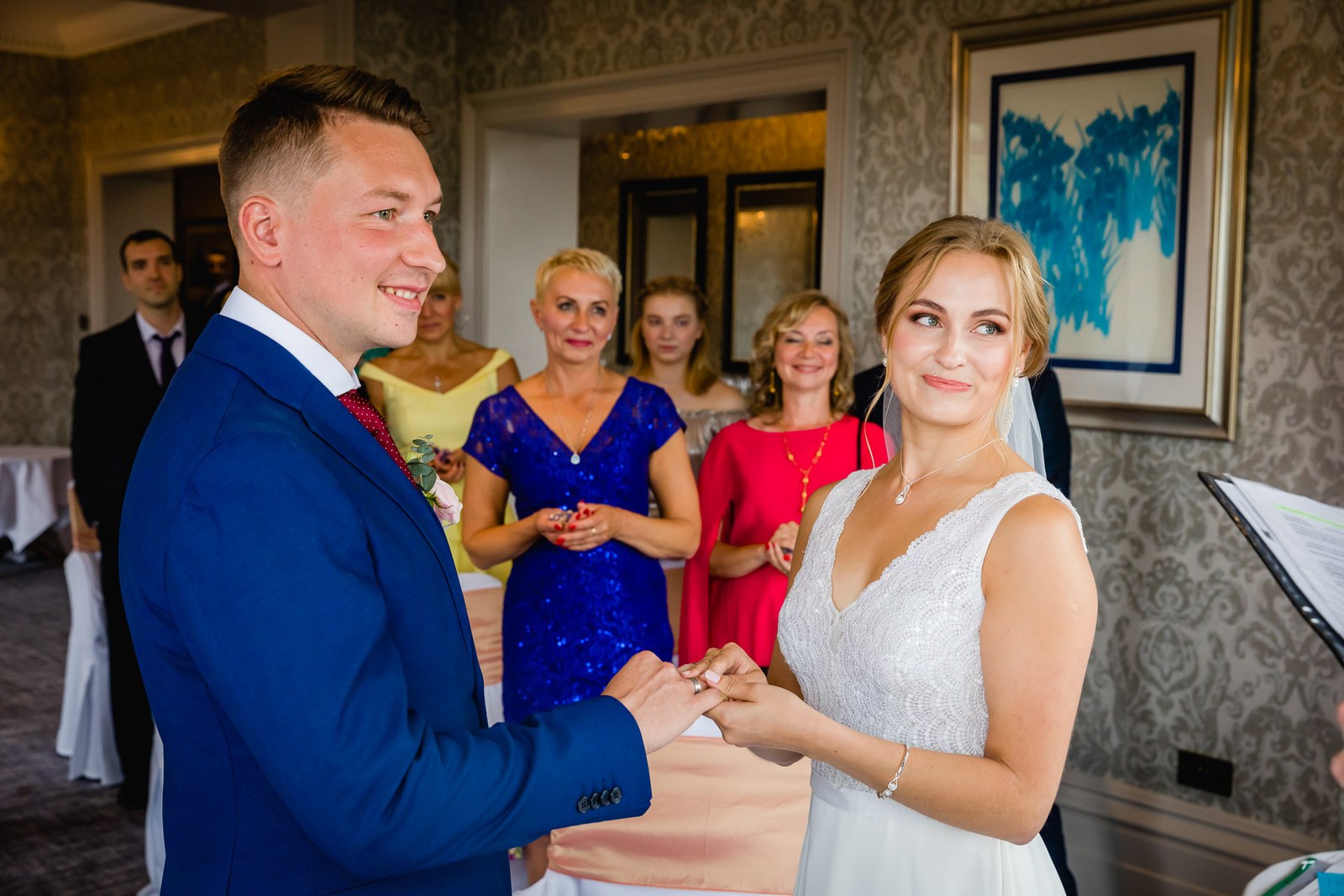 The couple exchanging rings as their guests look on
