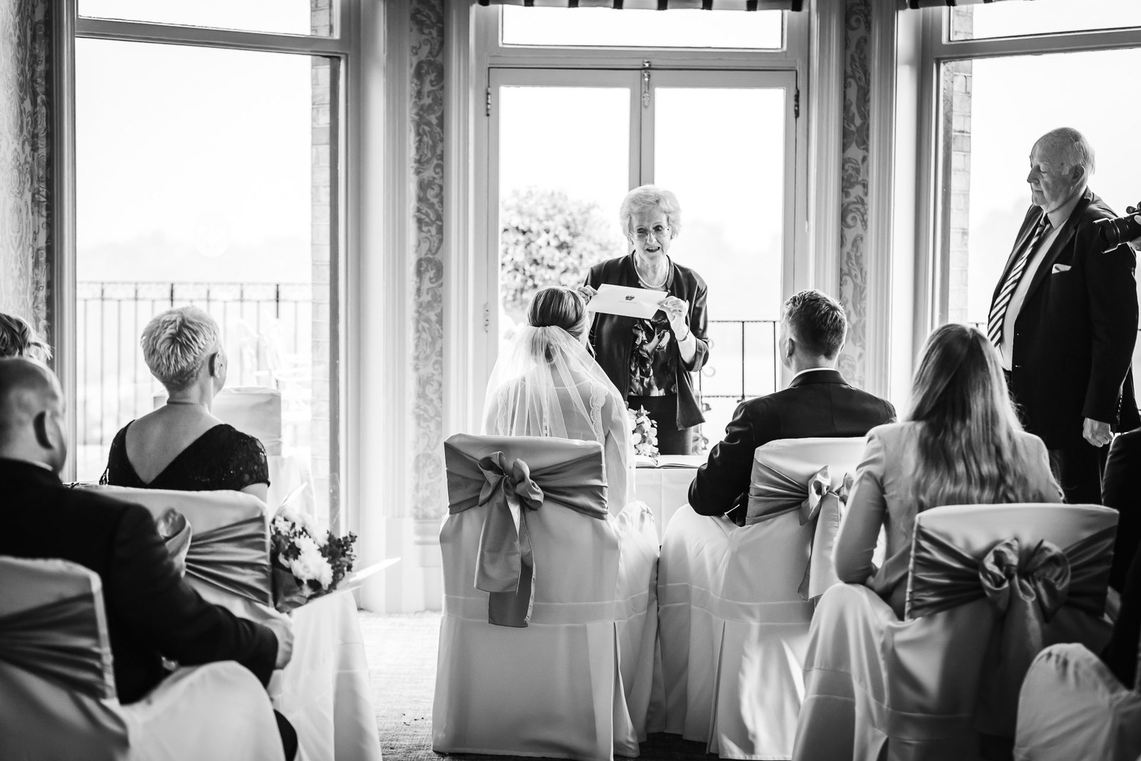 Black-and-white ceremony in a bay-windowed room at The Petersham Hotel
