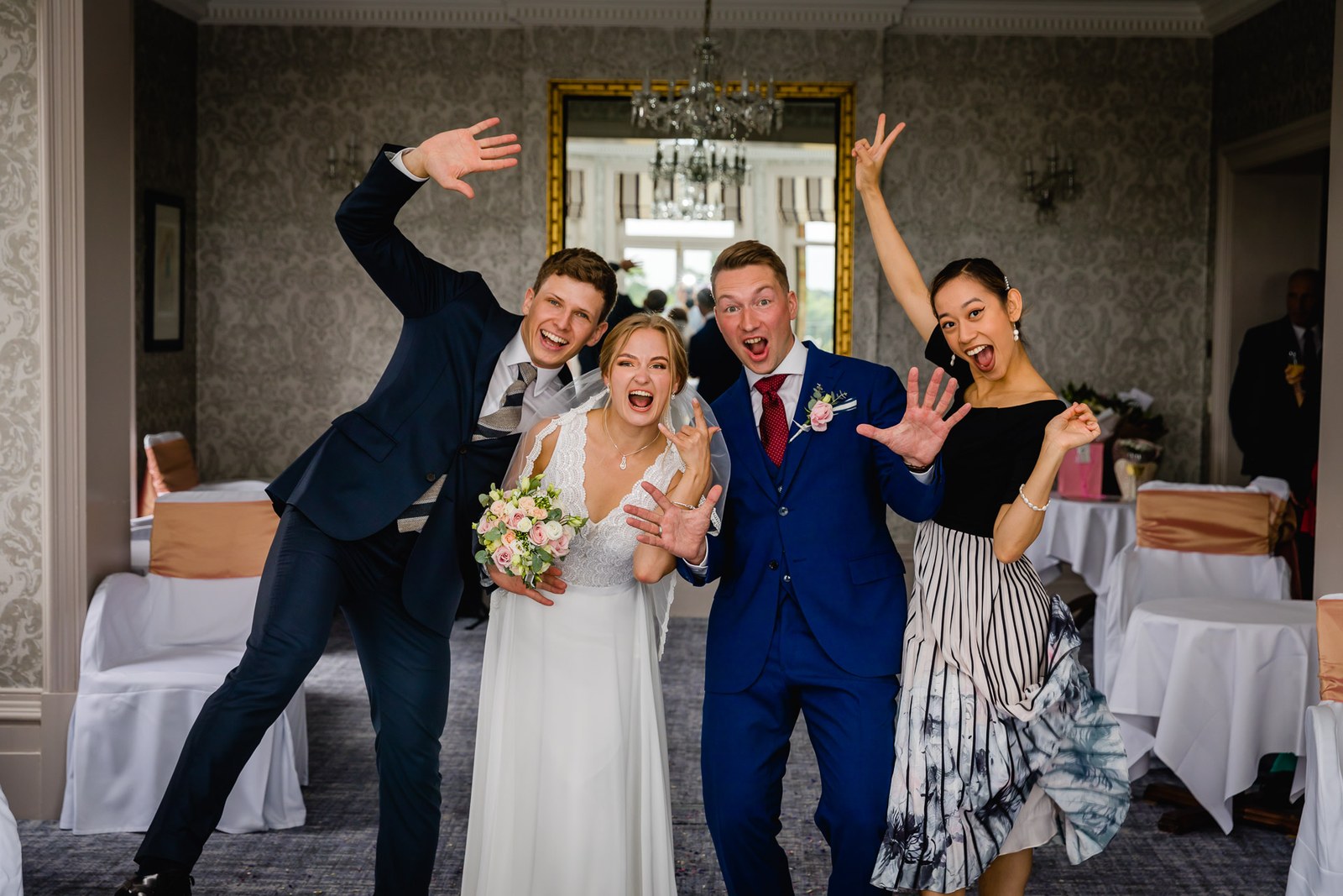 The couple and two guests posing playfully with arms outstretched