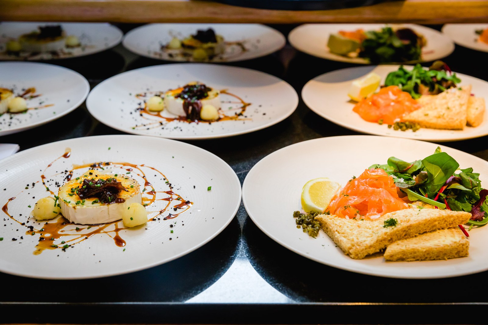 Plated smoked-salmon and cheese starters on white plates