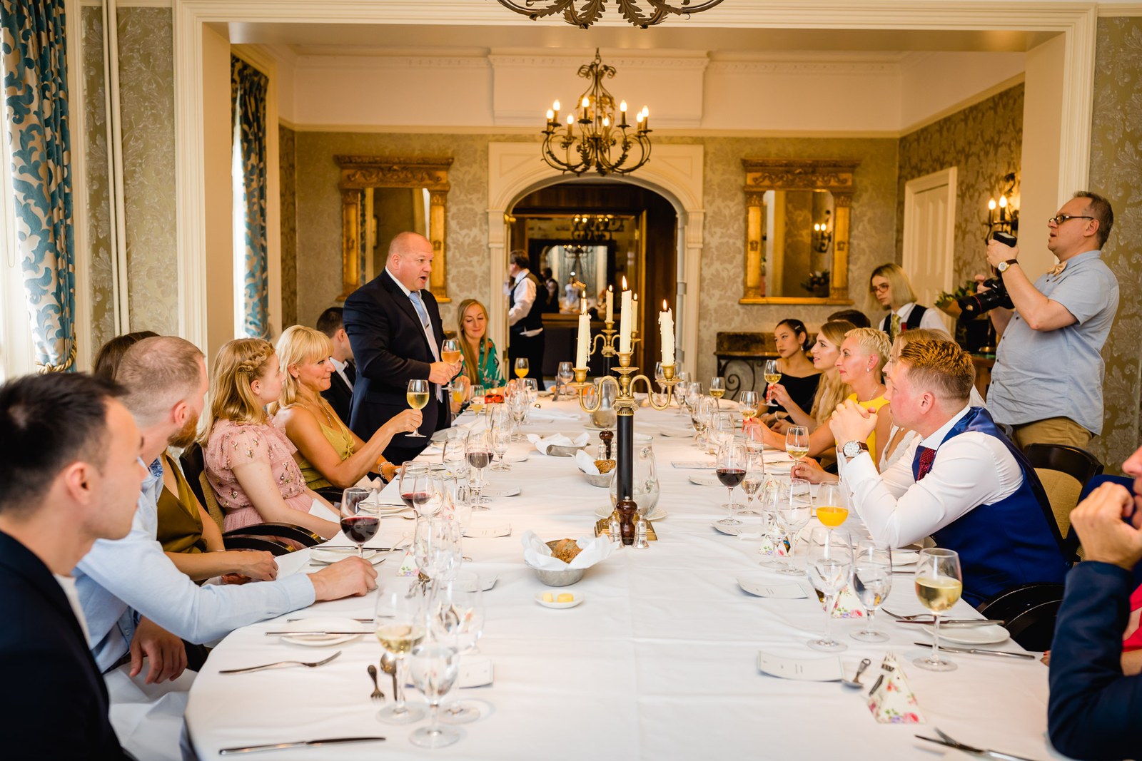 Guests dining along a long candlelit banquet table at The Petersham Hotel
