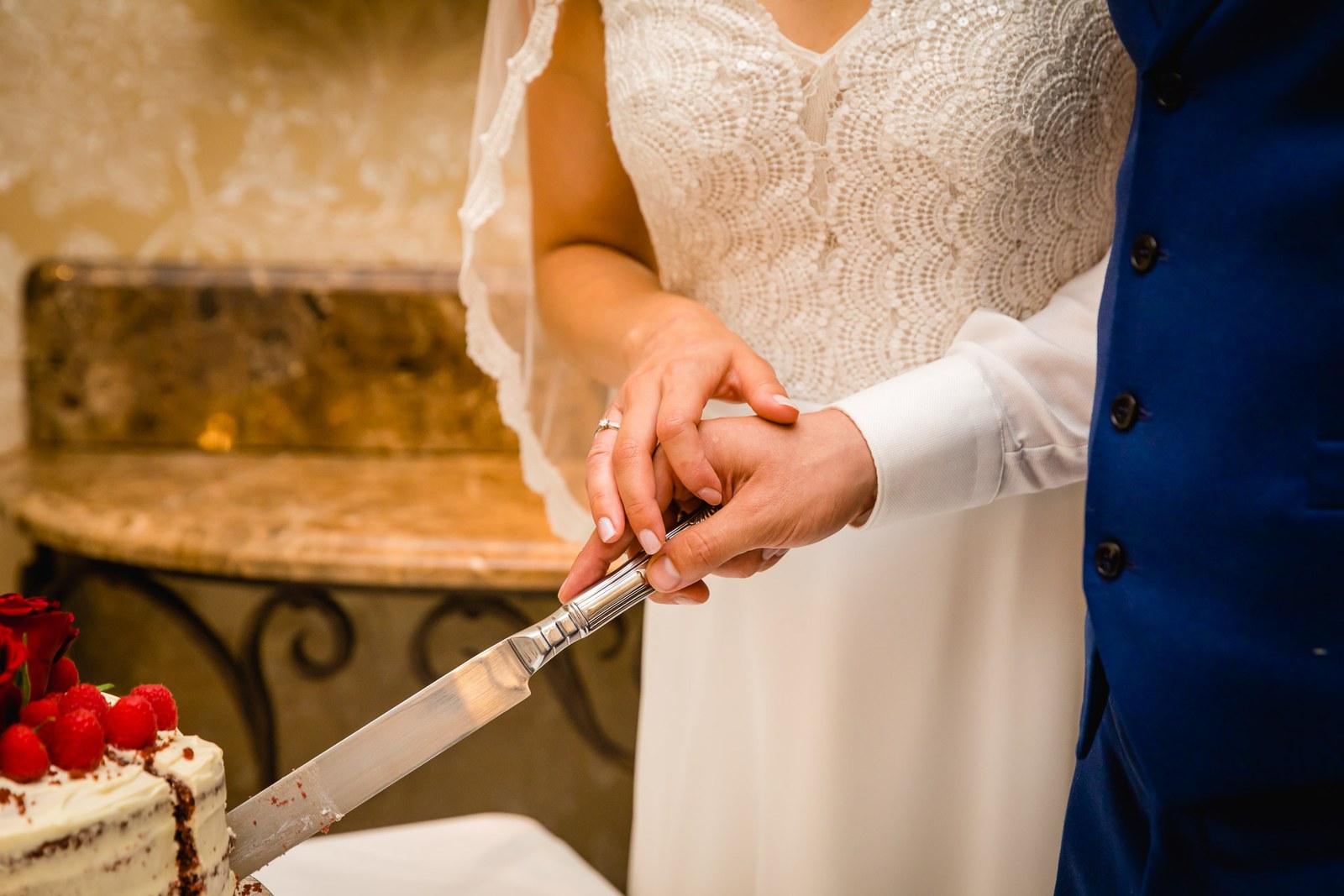 Close-up of the couple's hands cutting the cake with a knife