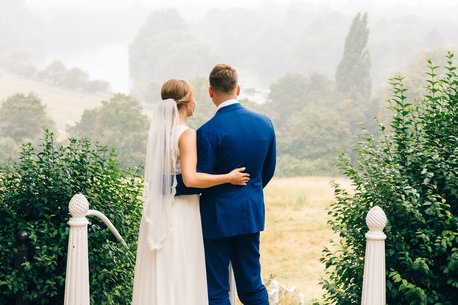 The couple embracing above the misty river view from Richmond Hill