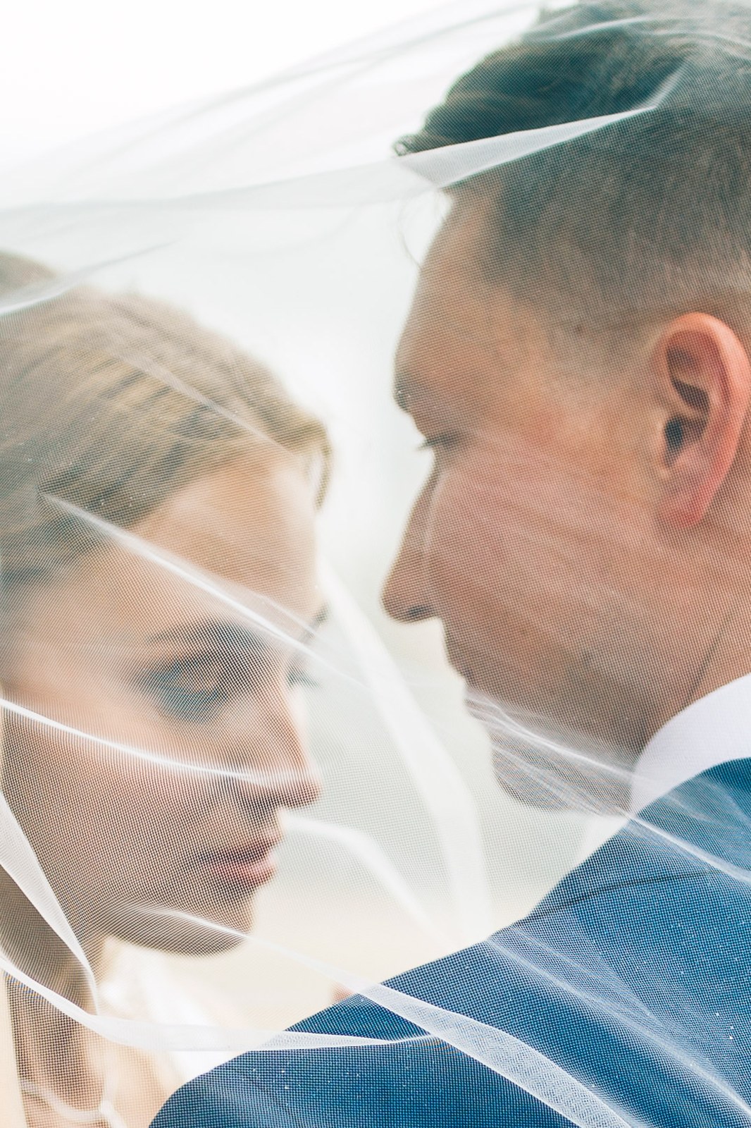 Close-up of the couple beneath the bride's veil