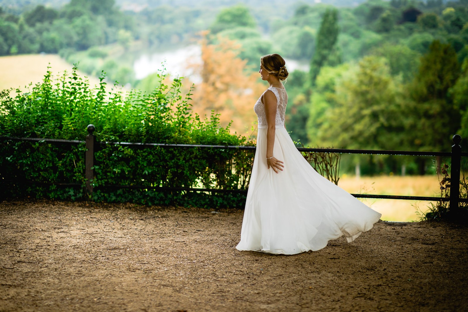 The bride posing by a rail above the Thames view from Richmond Hill