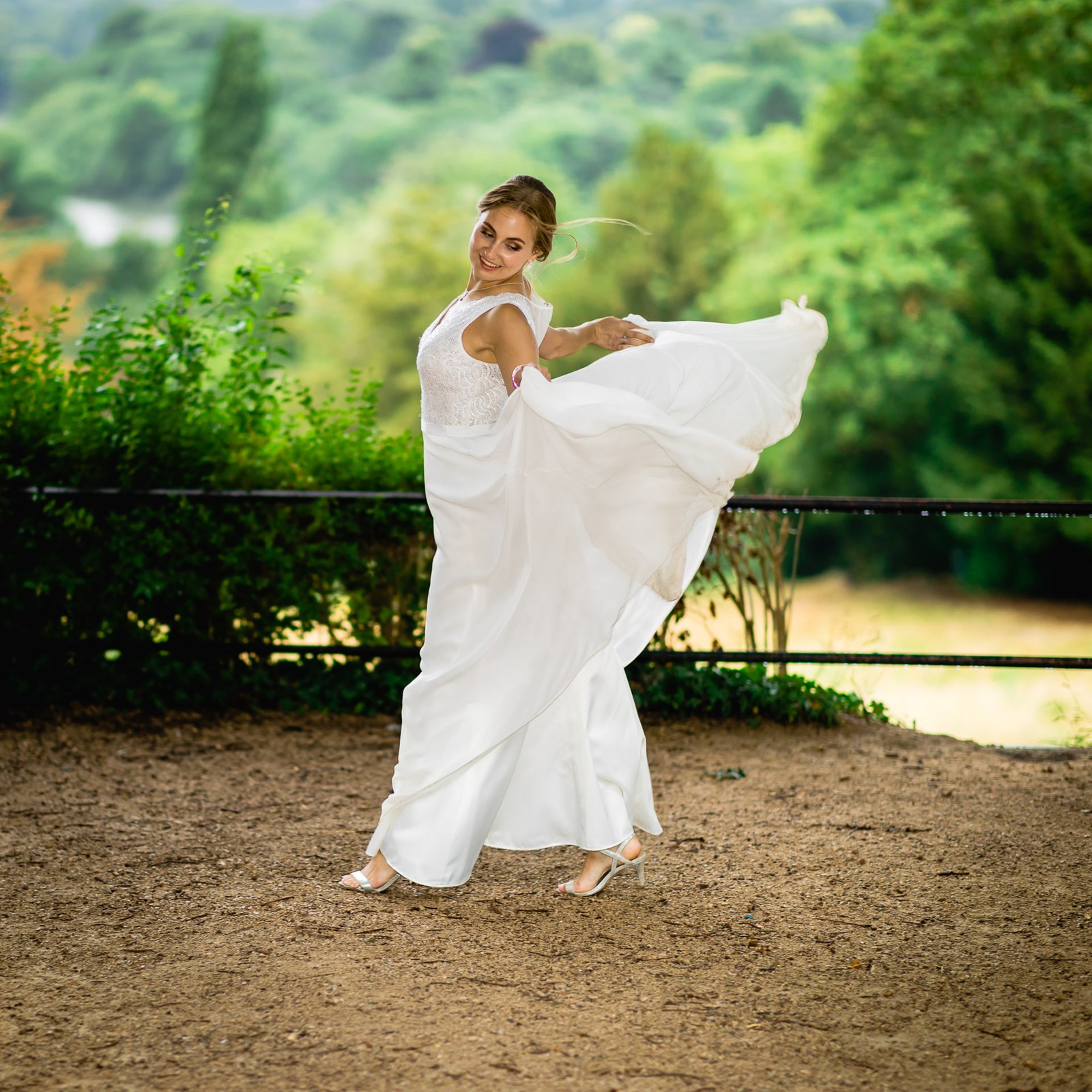 The bride twirling her flowing gown on a woodland path