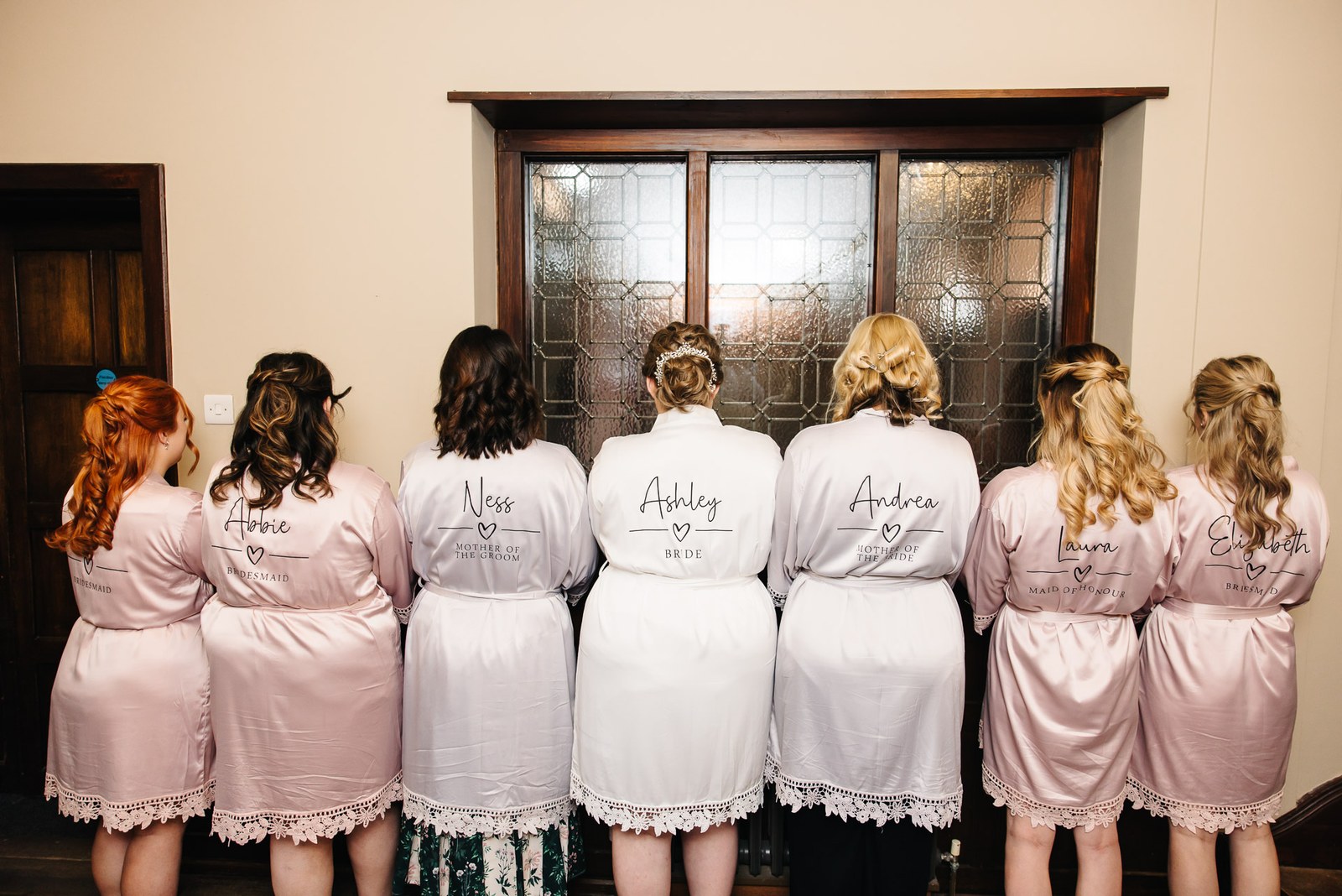 The bridal party in personalised robes viewed from behind before the ceremony