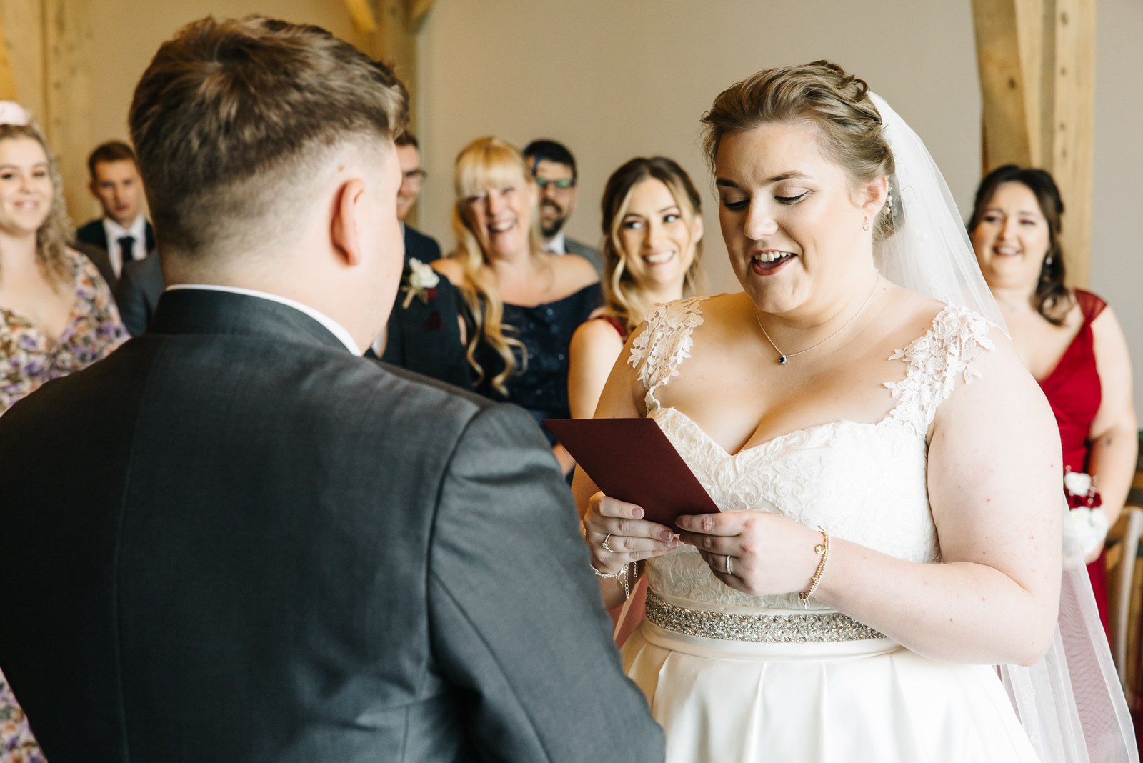 The bride reading her vows from a card to the groom