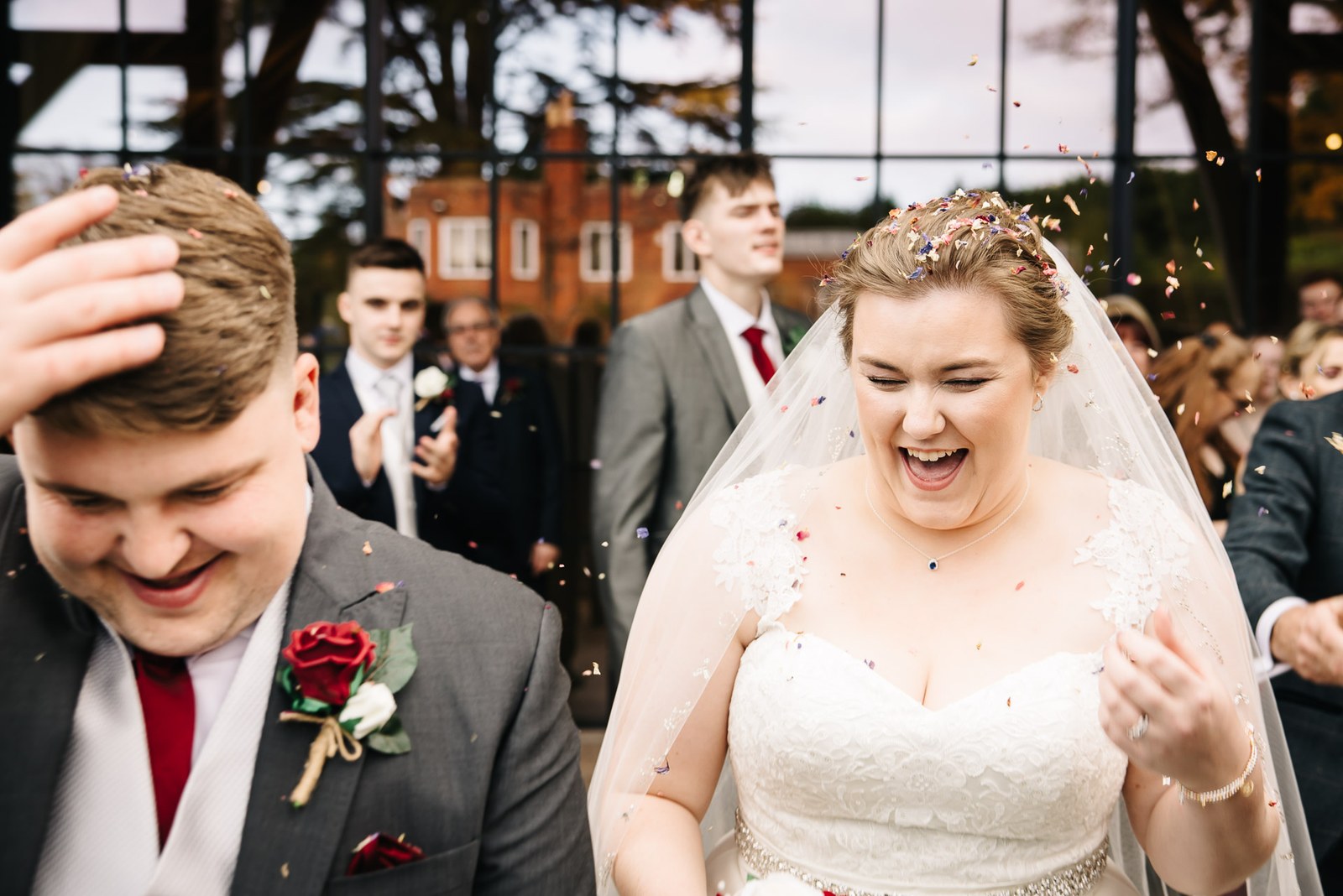 Close-up of the couple laughing as confetti falls around them