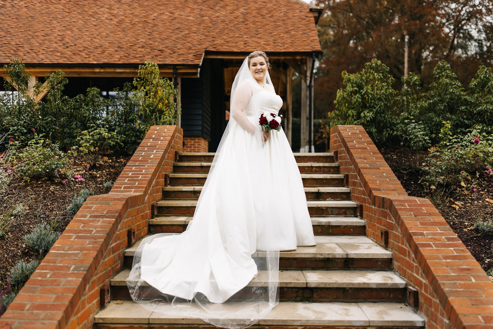 The bride alone on the brick steps, her veil and train spread out