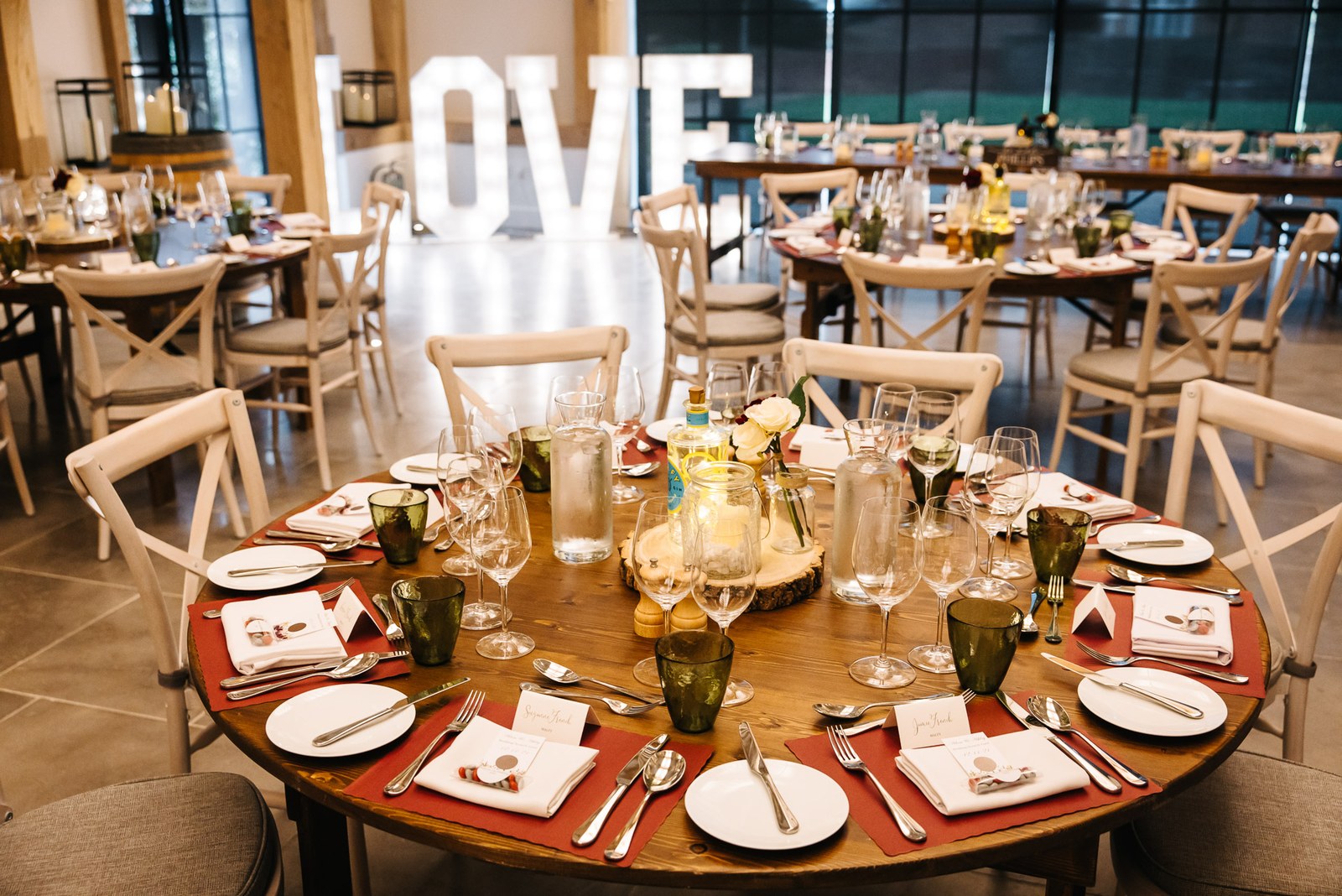The reception room at The Post Barn set with round tables and LOVE letters