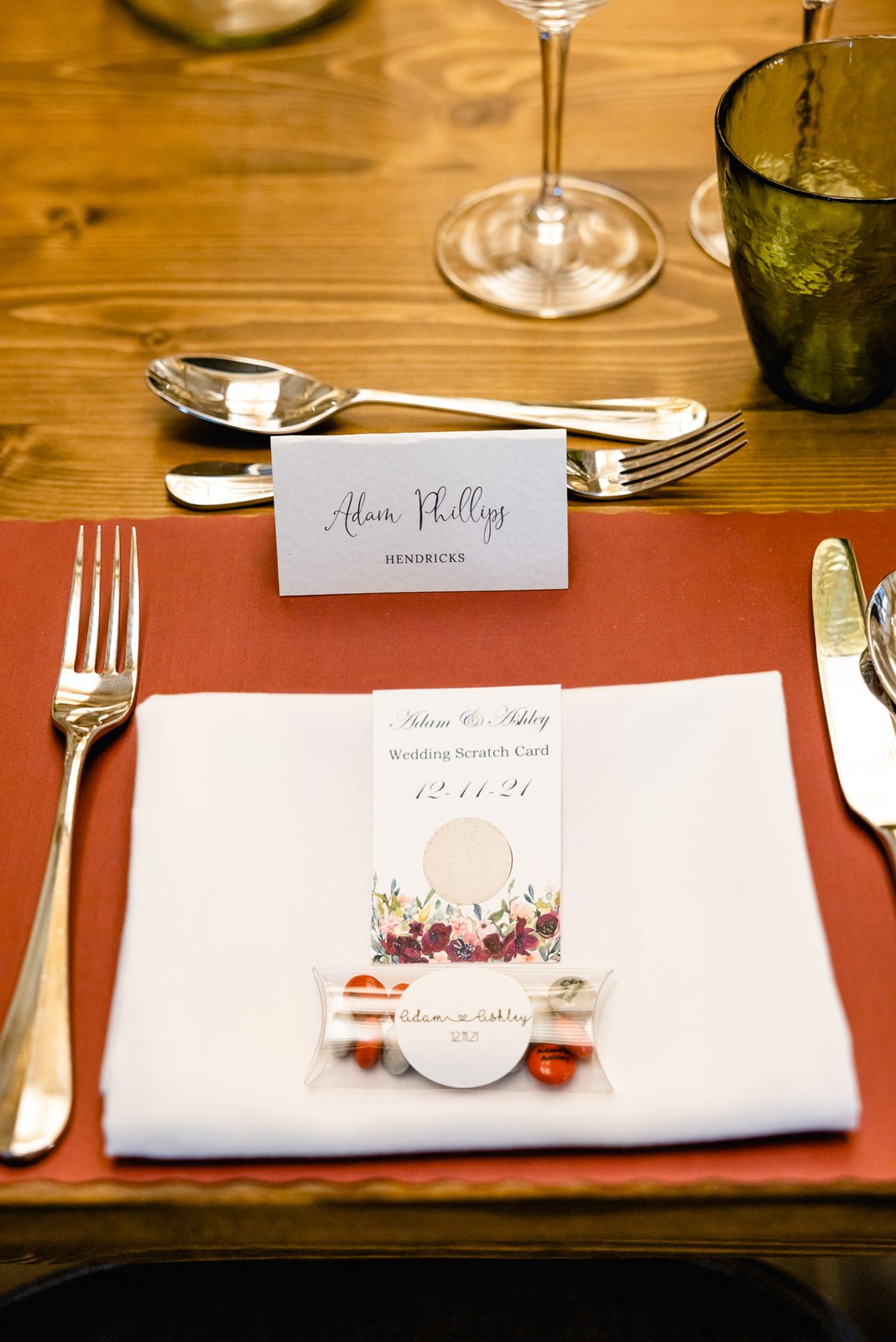 Close-up place setting with a scratch card, name card and cracker on a rust placemat