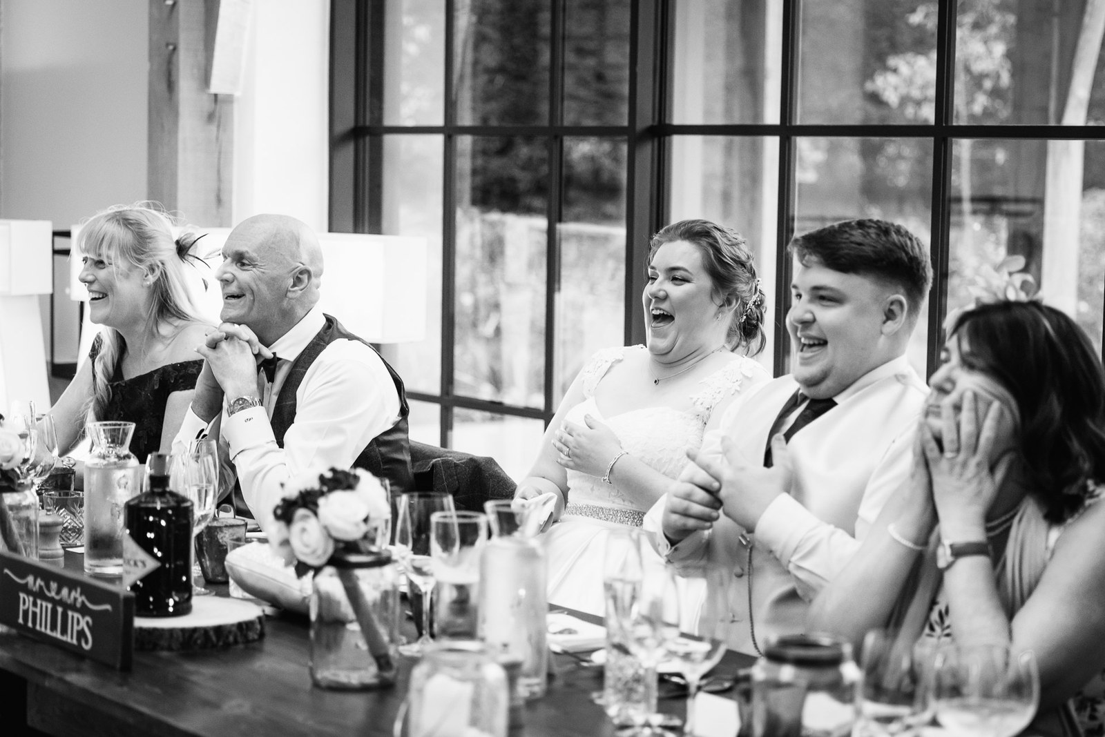 Black-and-white shot of the top table laughing during a speech