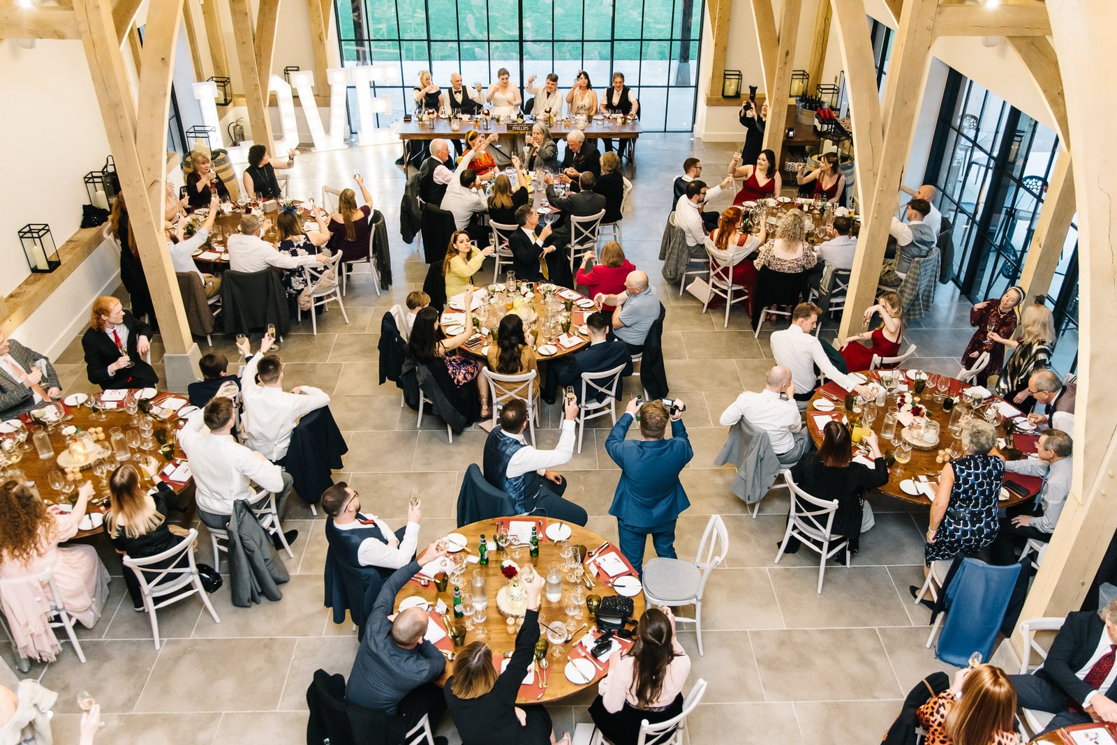 A high view of the reception filling the oak-framed barn at The Post Barn