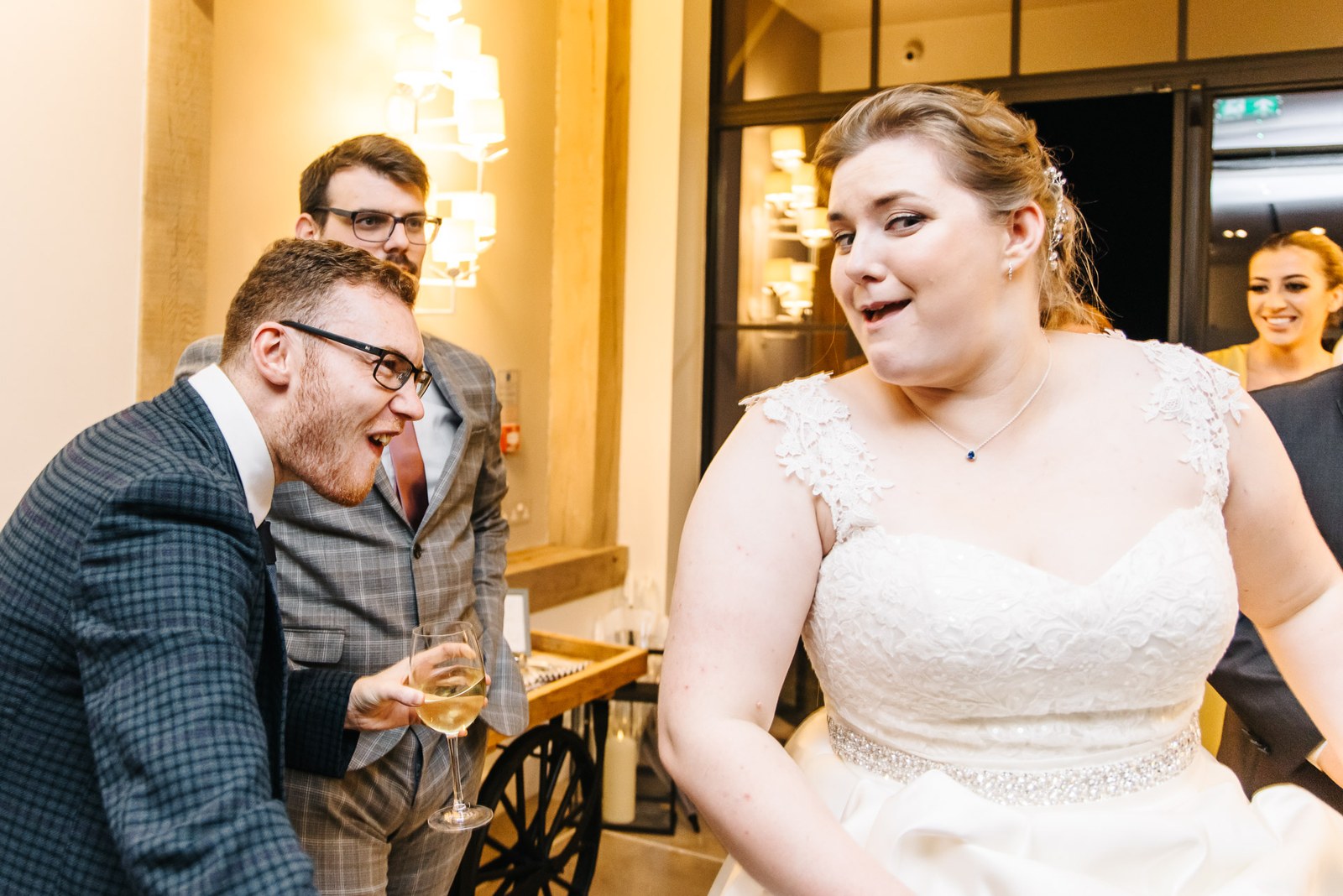 The bride reacting with a guest beside the drinks cart