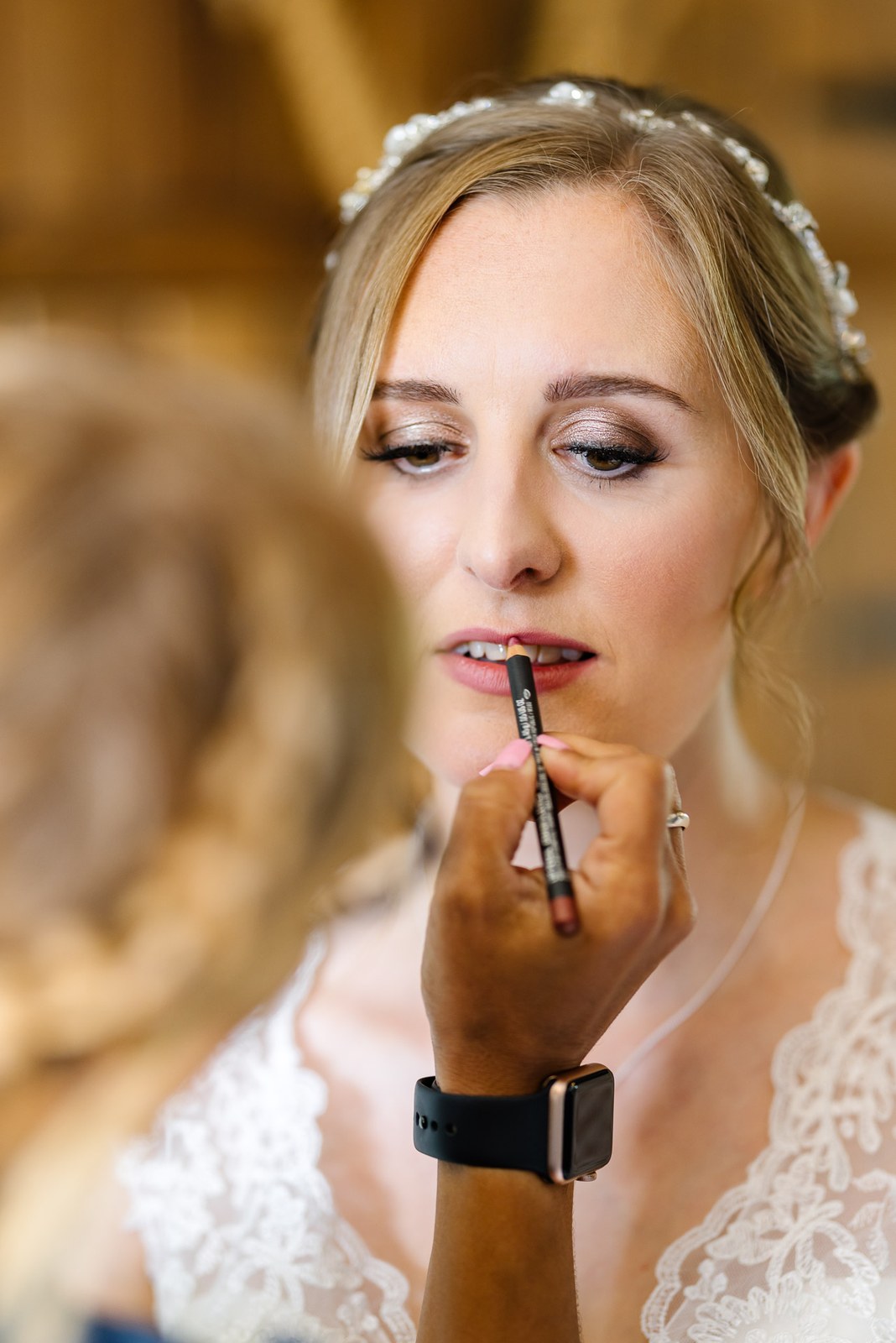 Close-up of a bride having lip colour applied before the ceremony