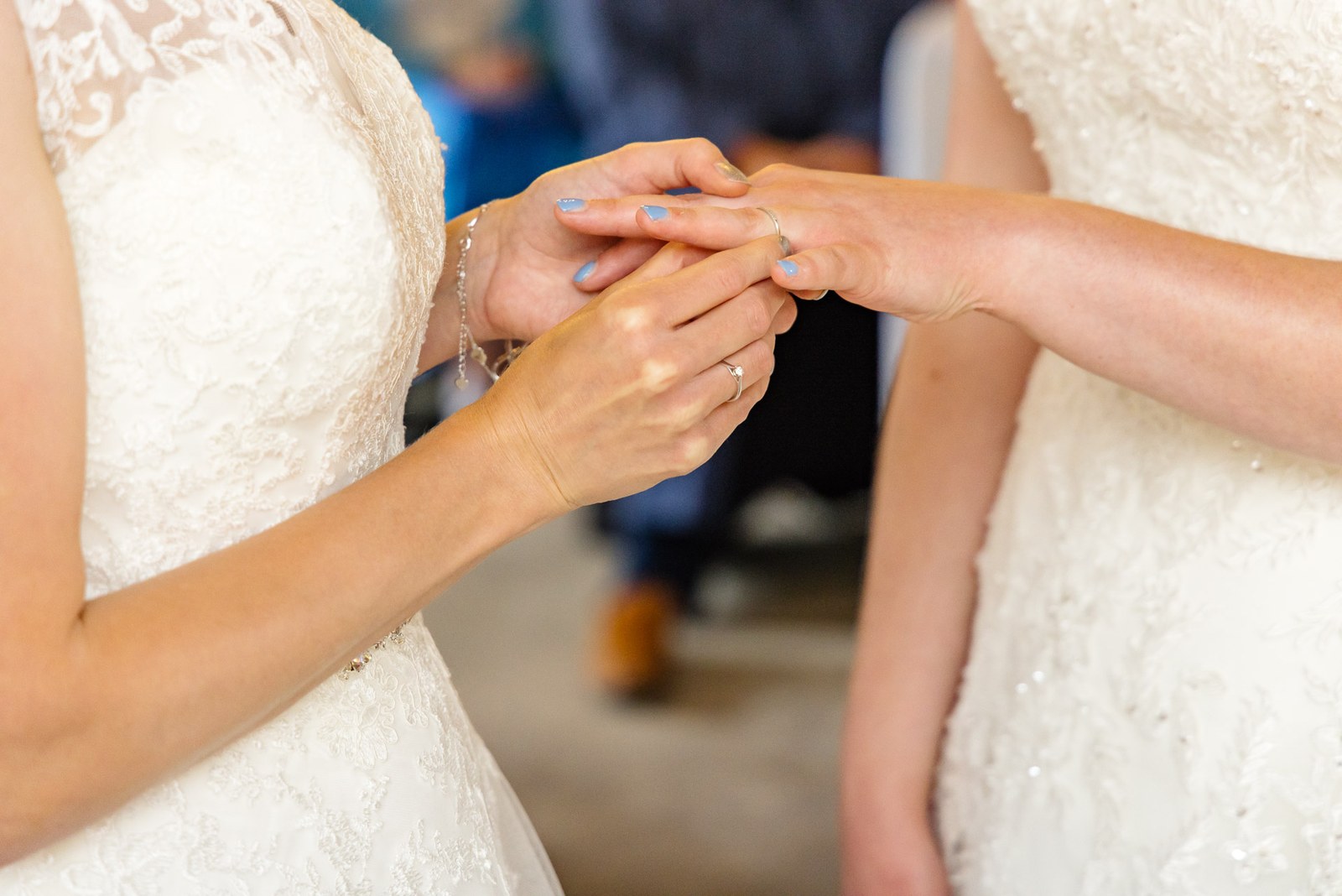 Close-up of the brides' hands as a wedding ring is exchanged