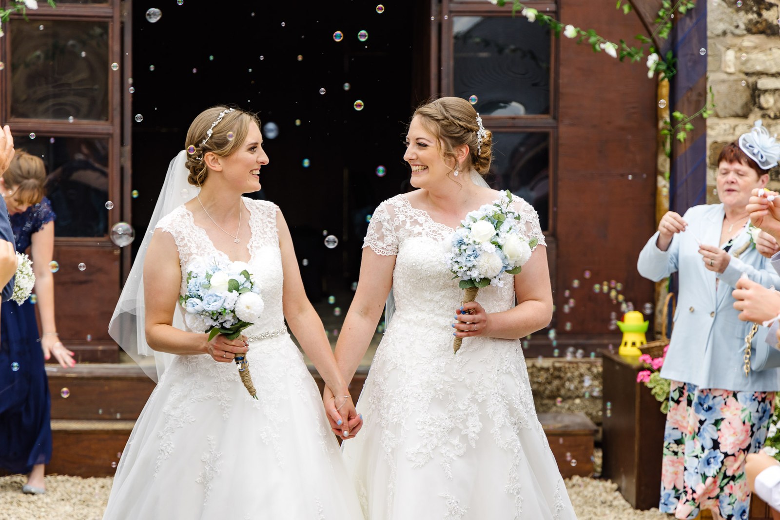 The newlyweds walk out through a flurry of bubbles blown by guests