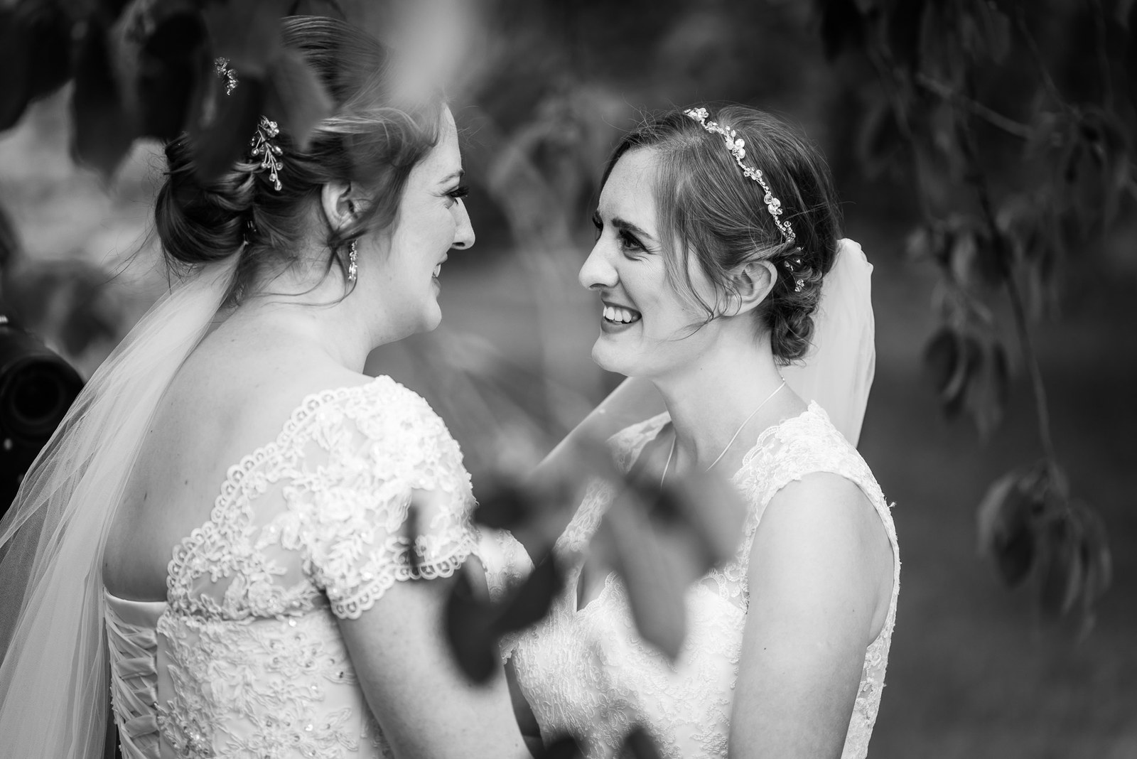 Black and white portrait of the brides laughing face to face