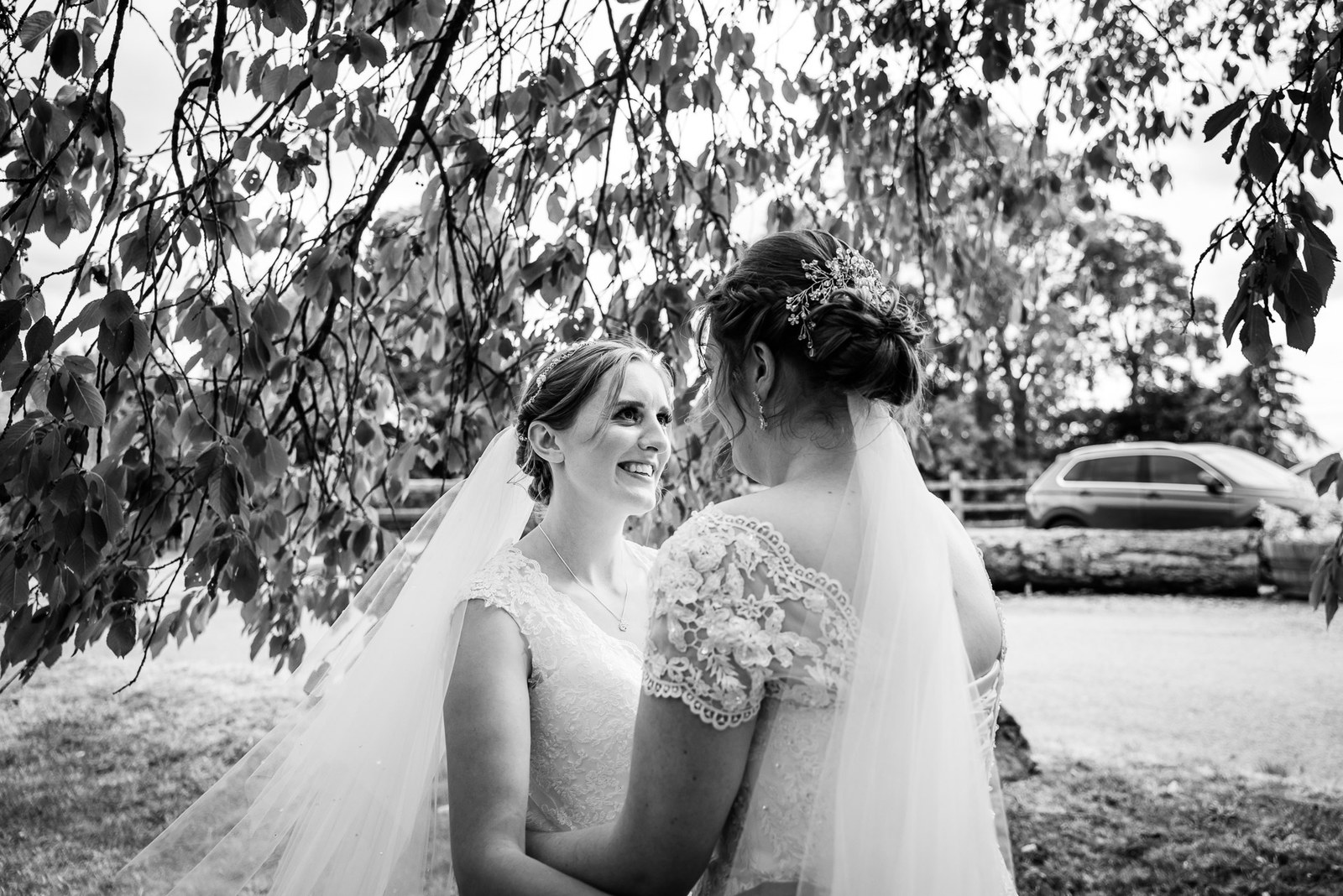 The couple share a quiet moment beneath overhanging branches, in monochrome