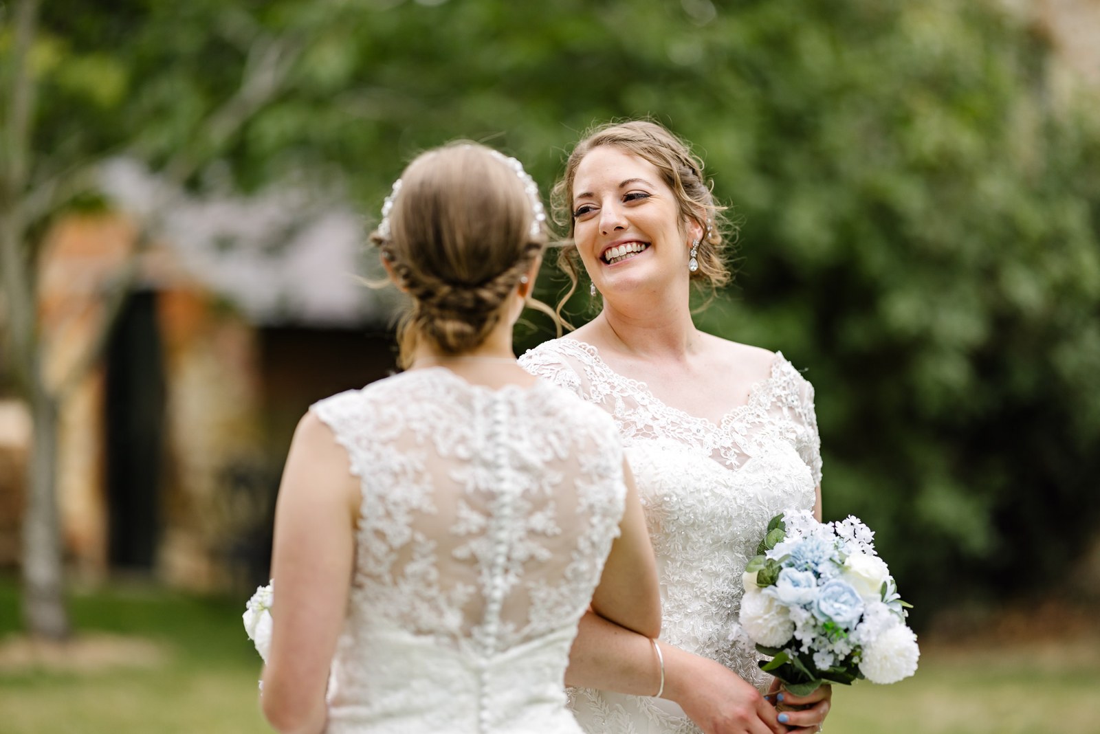 The couple walk away together, the lace back of a gown in view