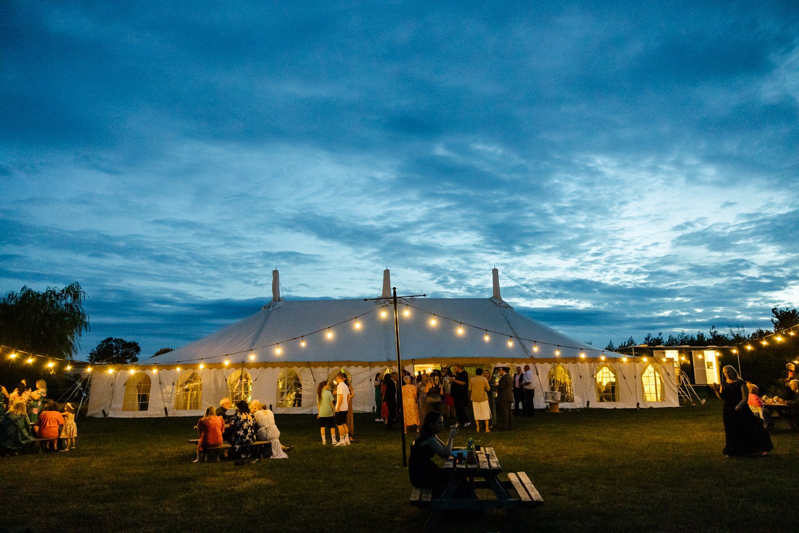 The Slapton Manor marquee glows with festoon lights against a blue-hour sky