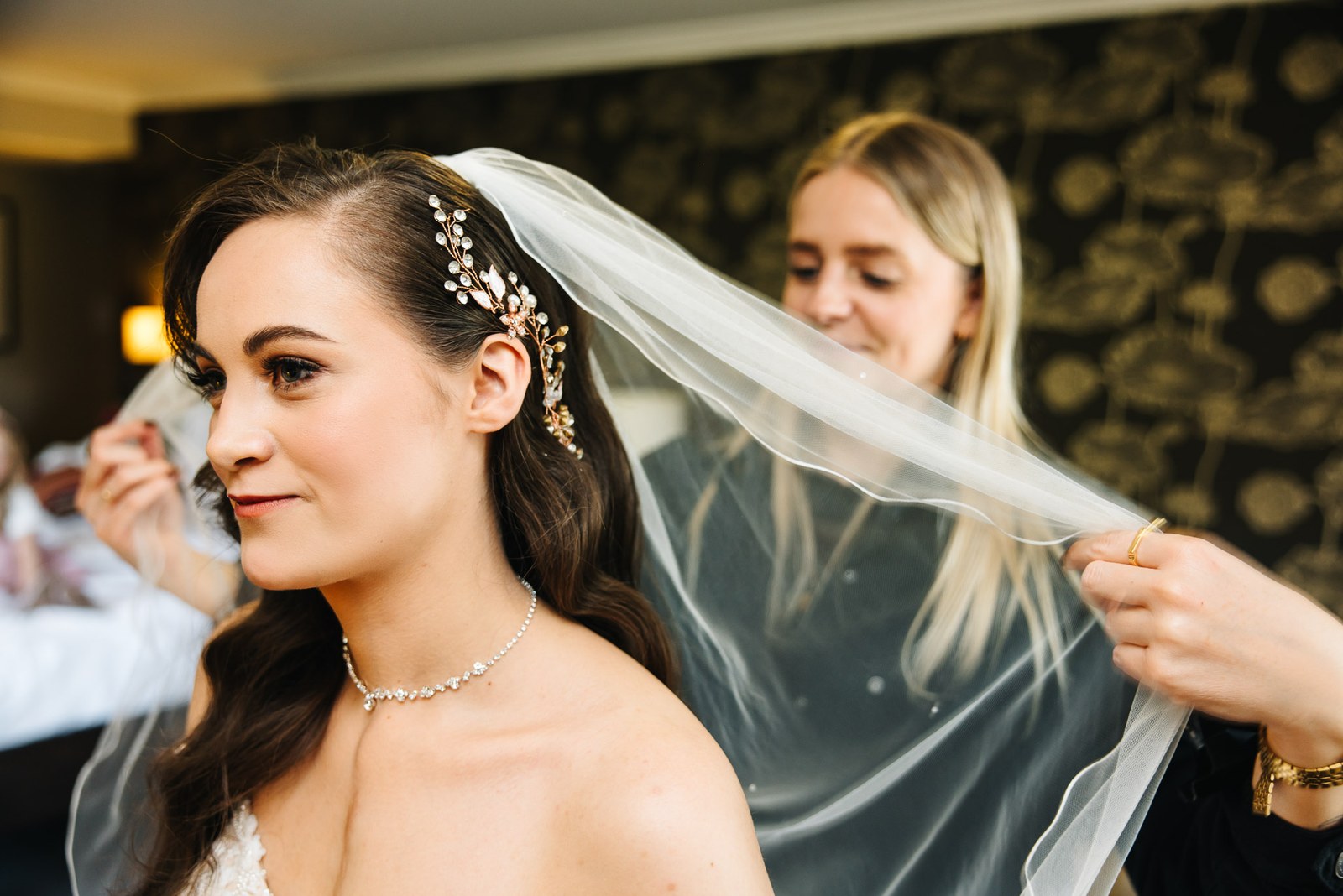 The veil is settled into the bride's hair before the ceremony