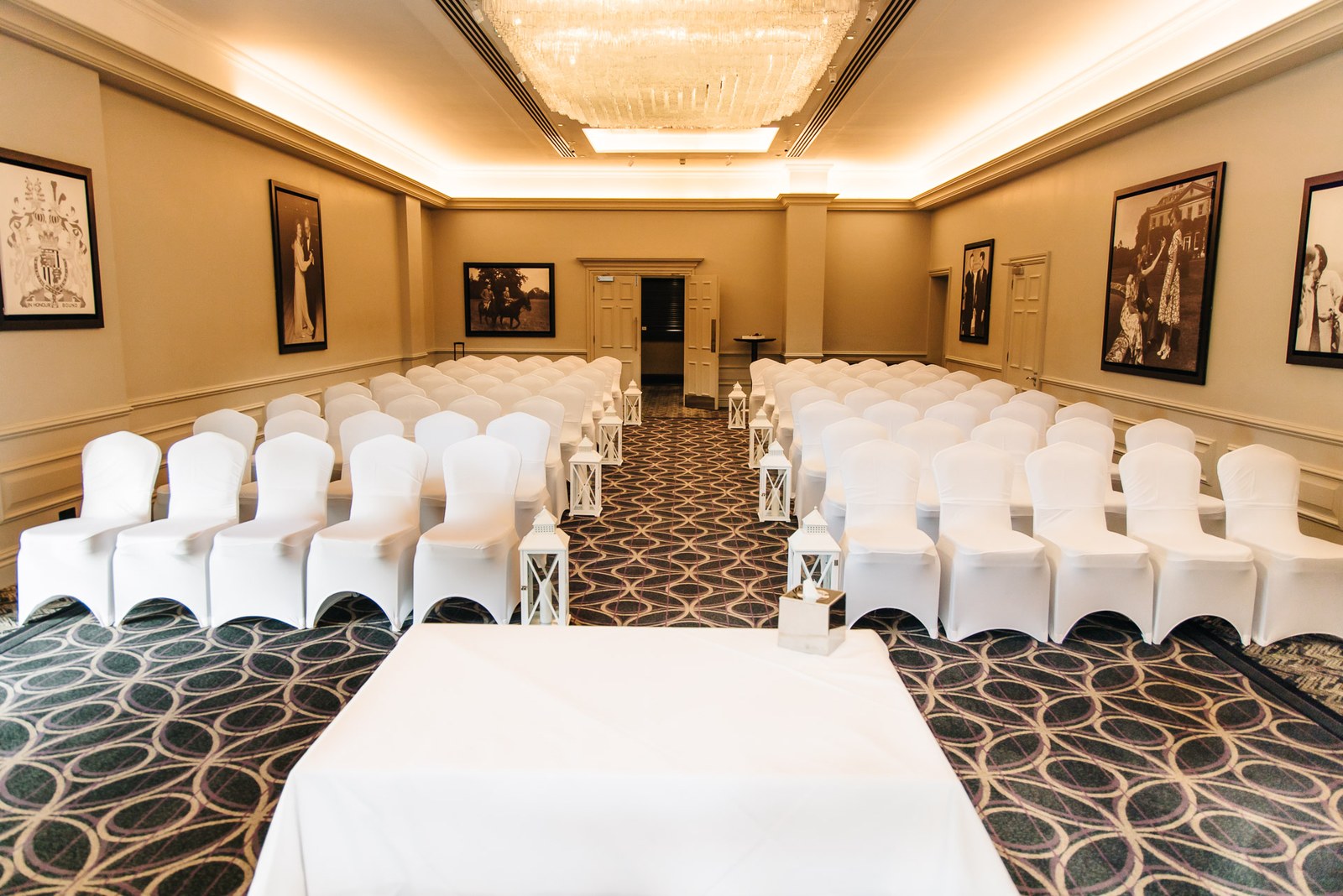The Sopwell House ceremony room set with white-draped chairs and lanterns down the aisle