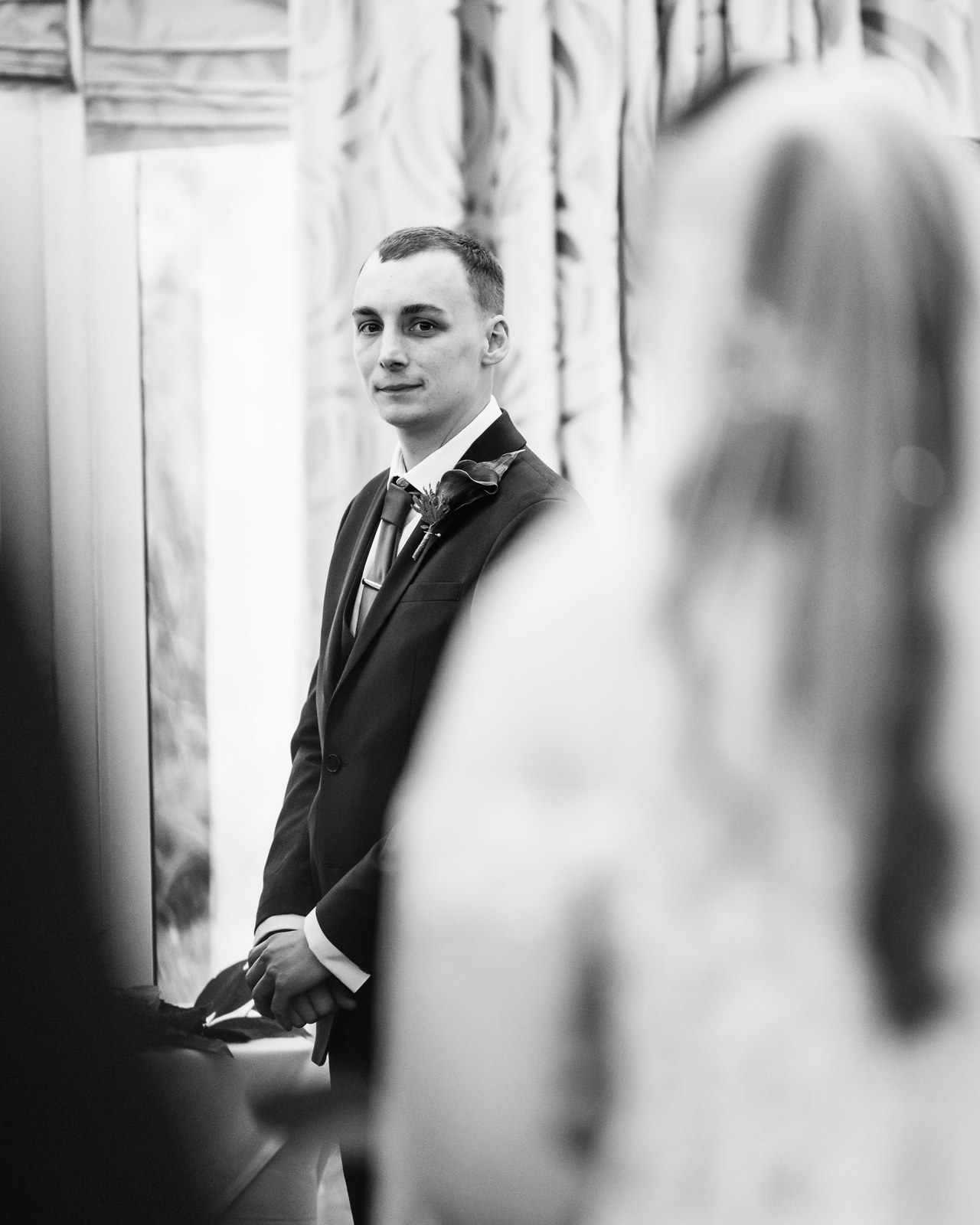 Black and white portrait of the groom waiting at the ceremony