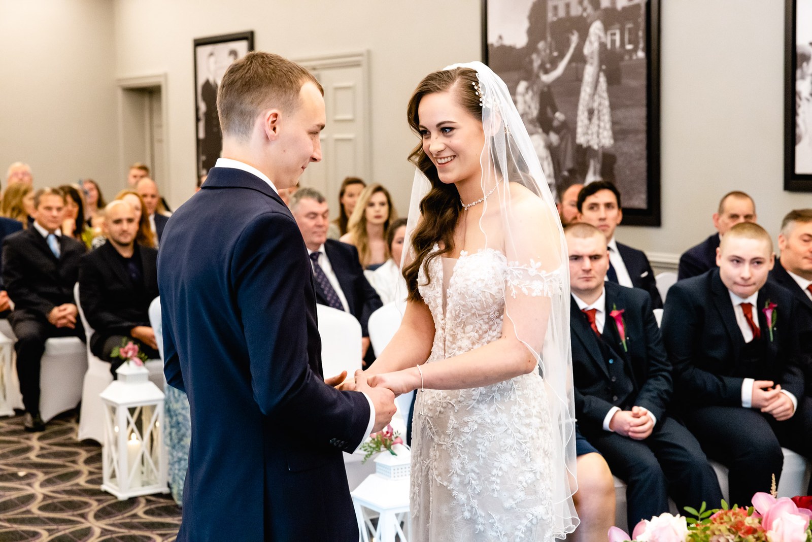 The bride and groom hold hands facing each other during the ceremony