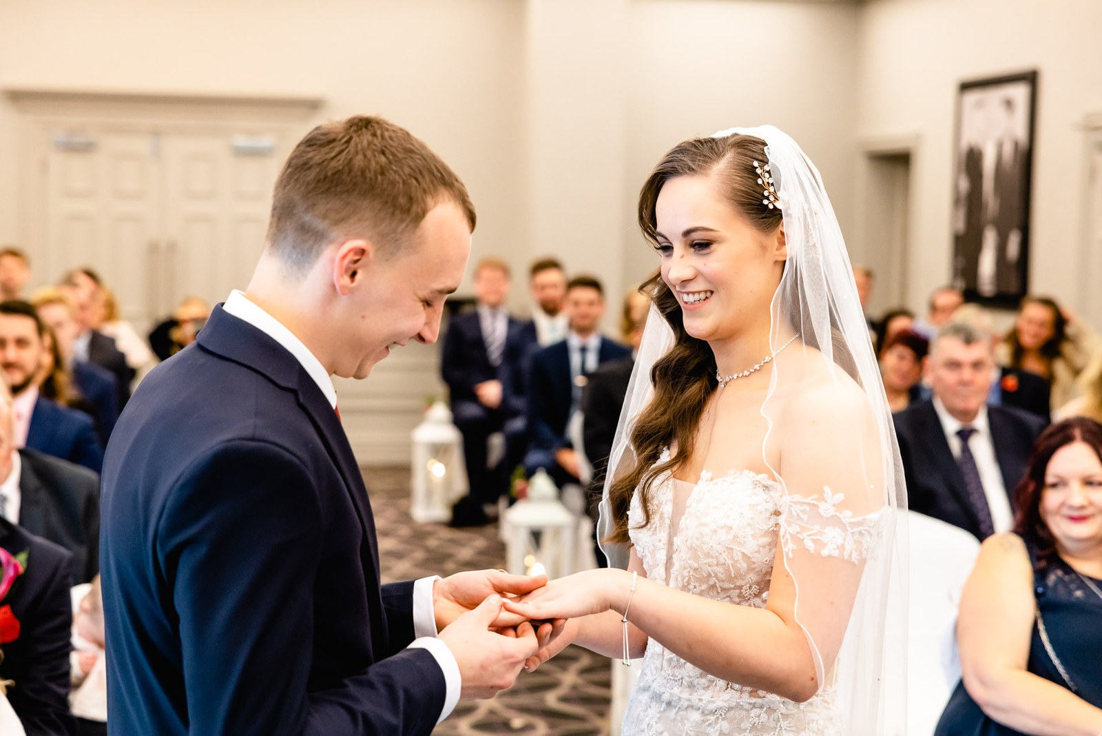The groom slides the wedding ring onto the bride's finger
