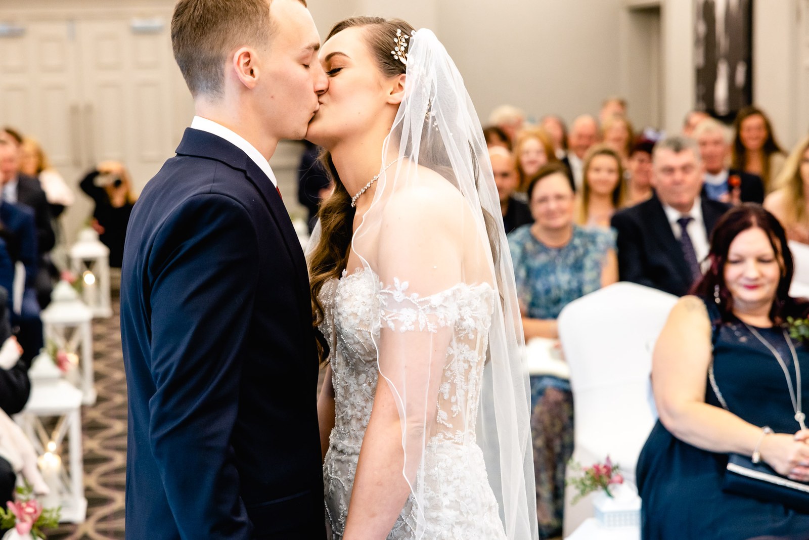 The couple share their first kiss as guests look on and smile