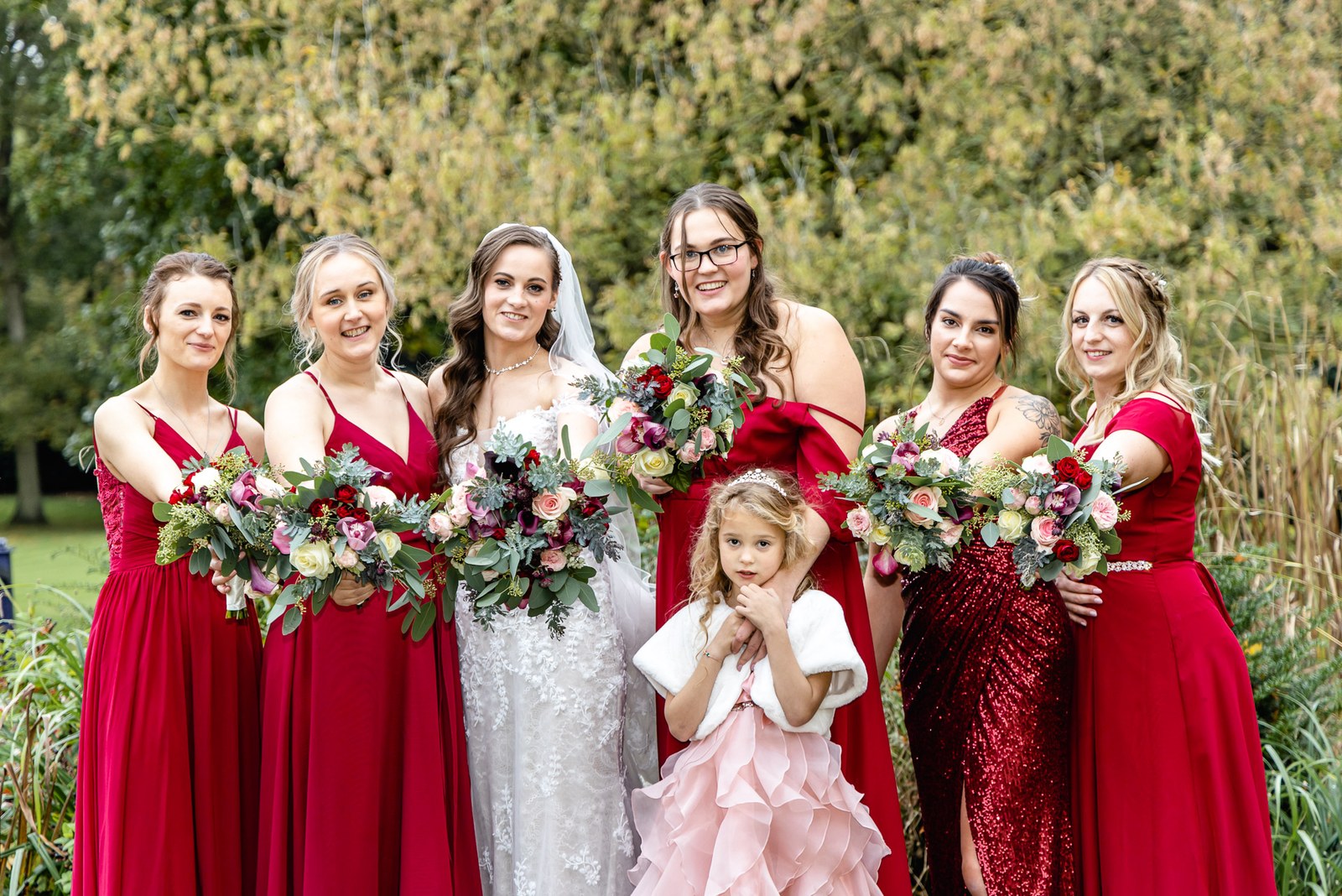 Bride with her red-dressed bridesmaids and a flower girl in the Sopwell House gardens