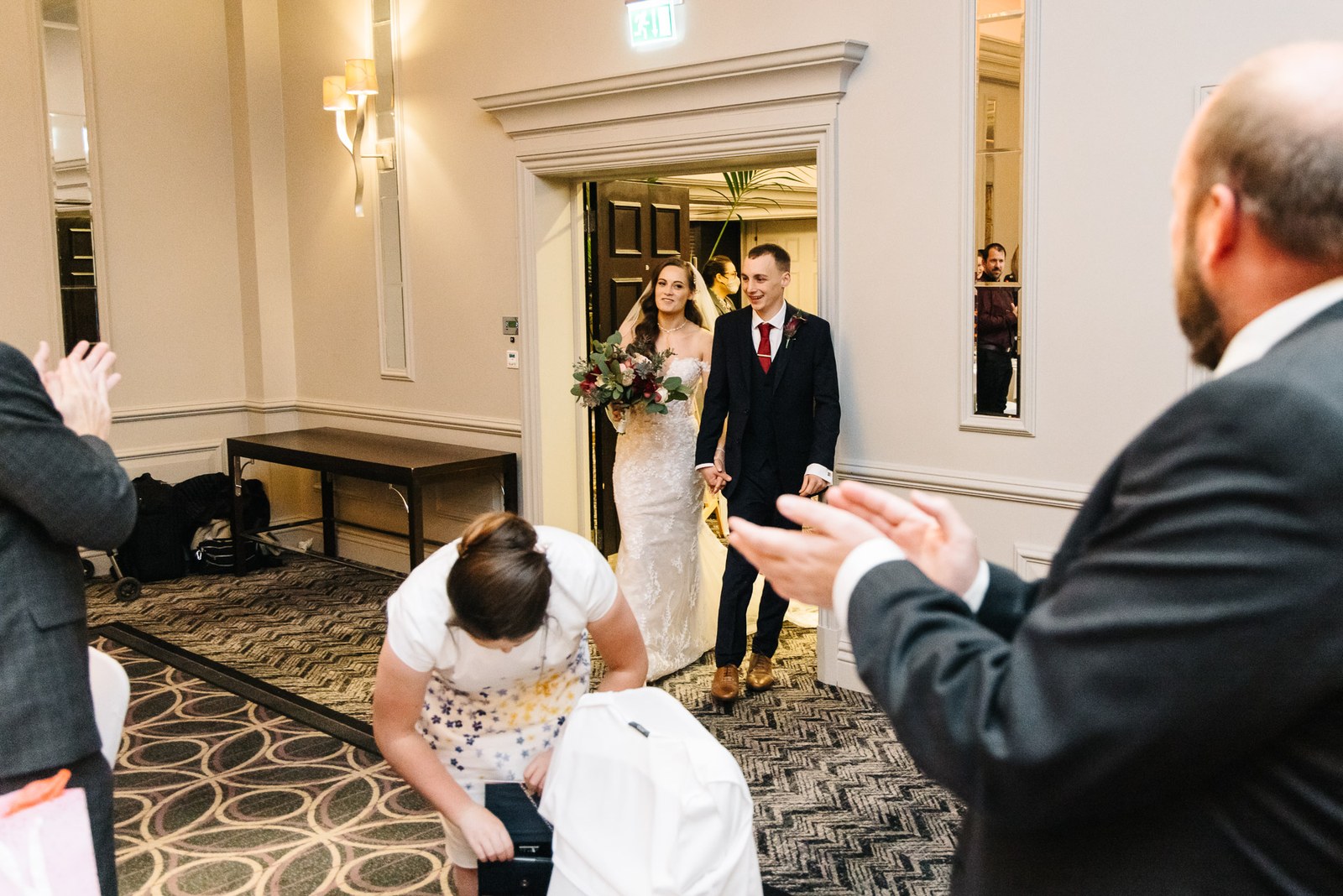 The newlyweds enter the Sopwell House reception to applauding guests