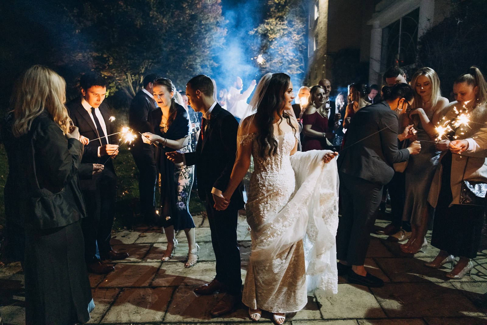 The newlyweds pass through a sparkler send-off outside Sopwell House at night