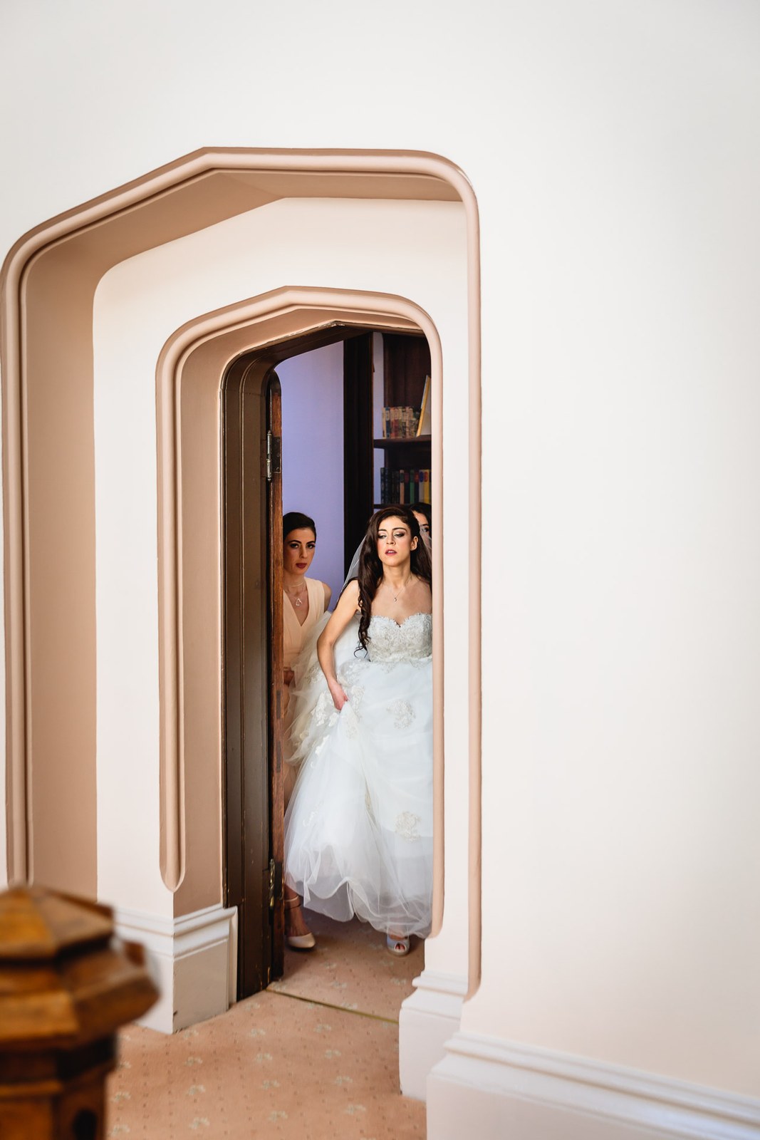 Bride steps through an arched doorway in her flowing gown