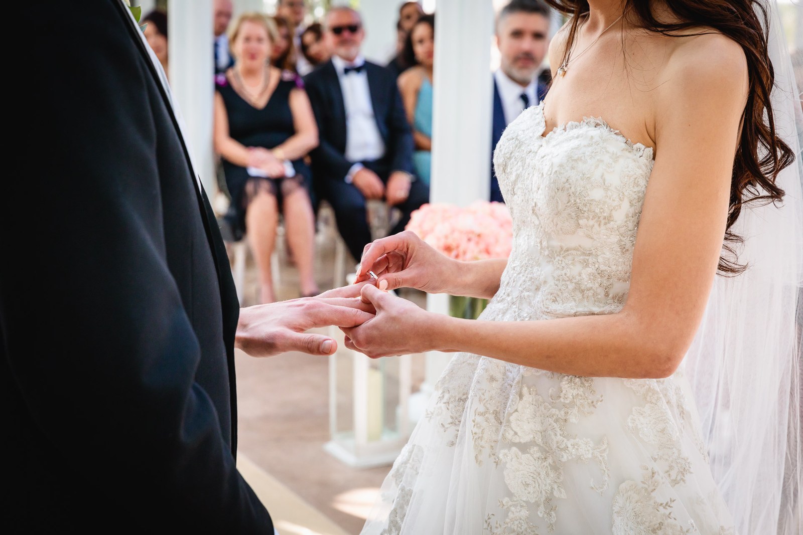 The bride slides the wedding ring onto the groom's finger