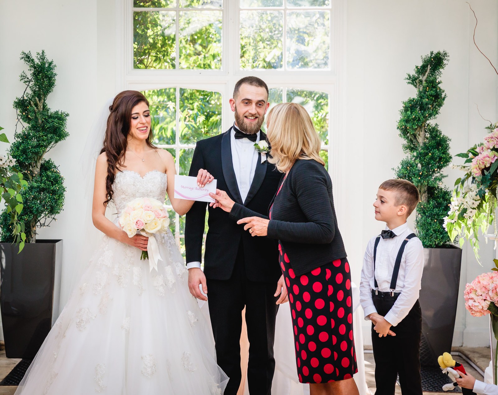 The couple receive their certificate from the registrar amid the greenery