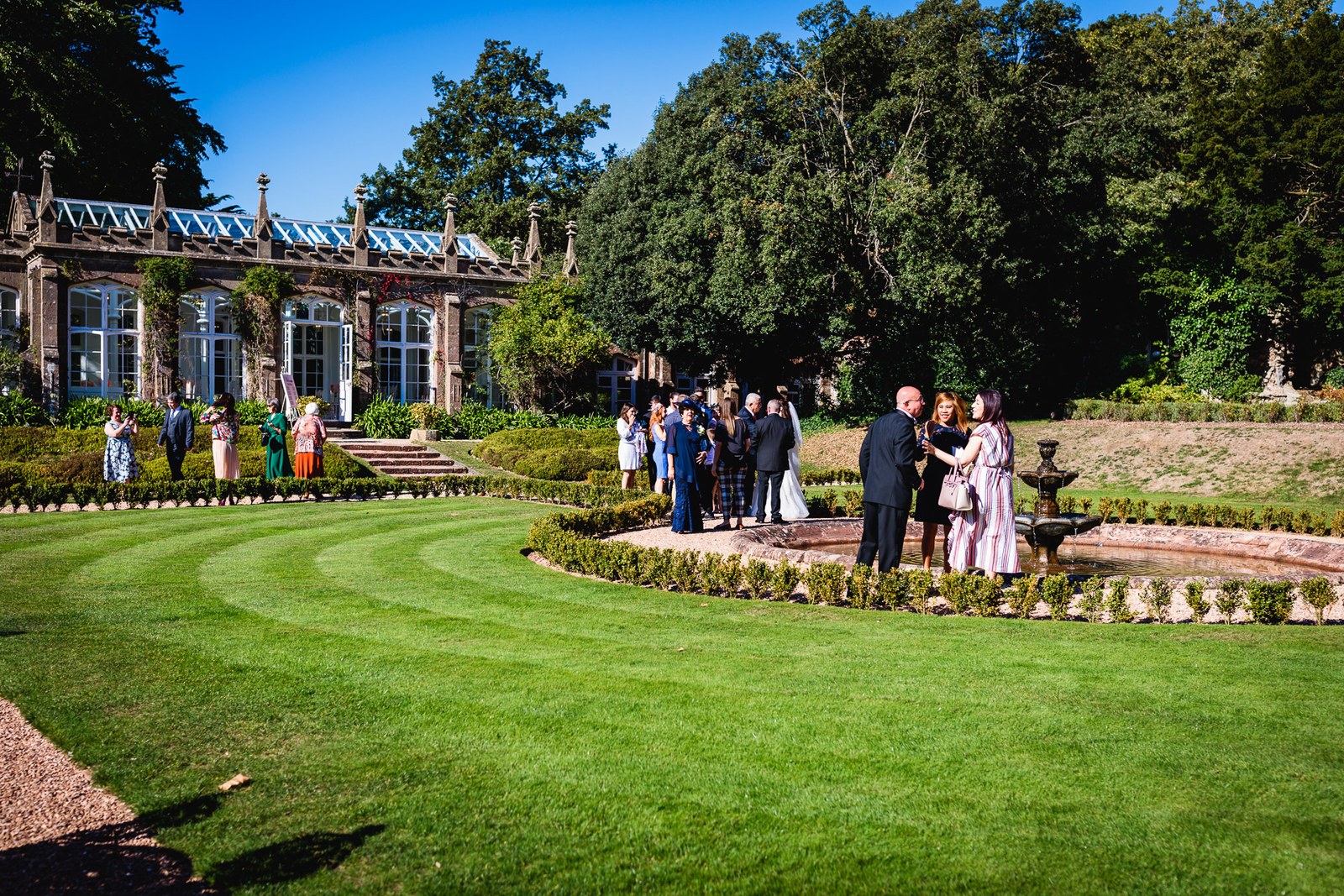 Guests gather on the formal lawns and fountain garden of St Audries Park