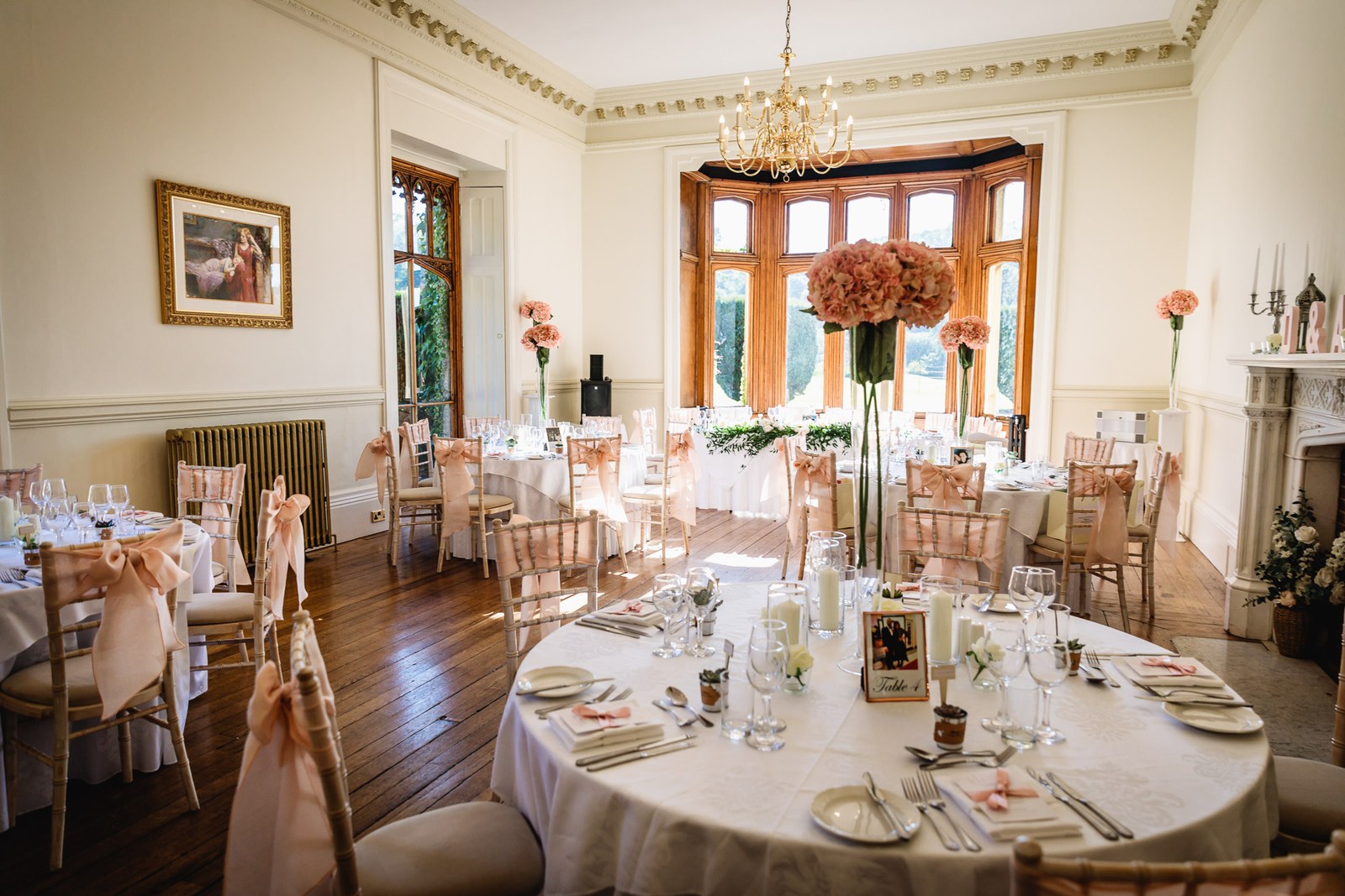The St Audries Park dining room set with round tables beneath a chandelier
