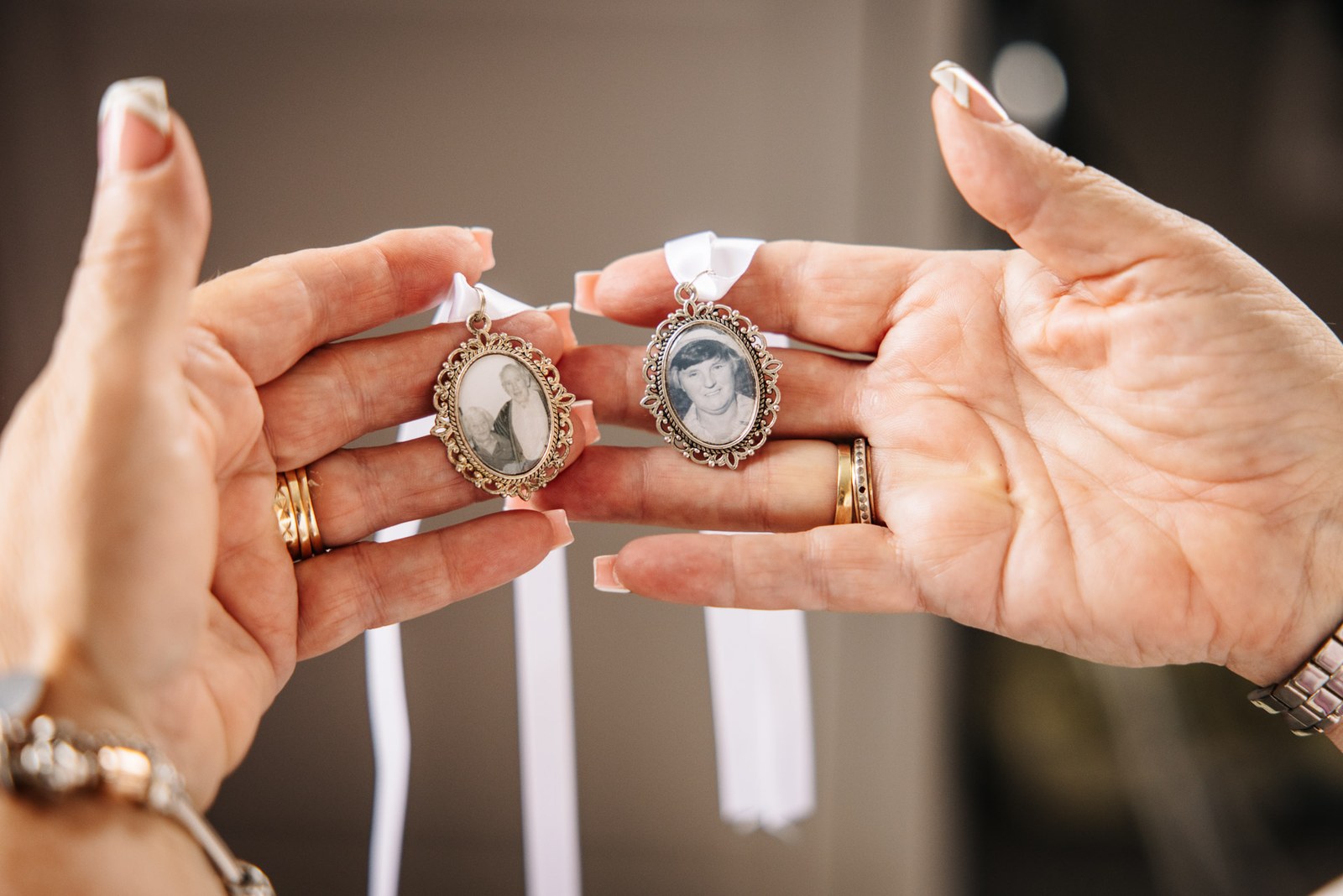Two oval lockets holding family photographs, carried in memory on the bouquet