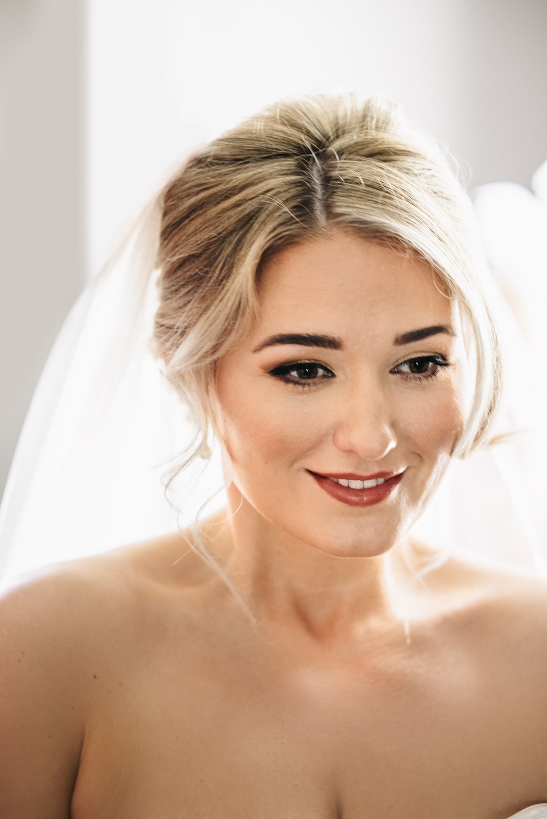 Soft portrait of the bride in her veil, ready for the ceremony