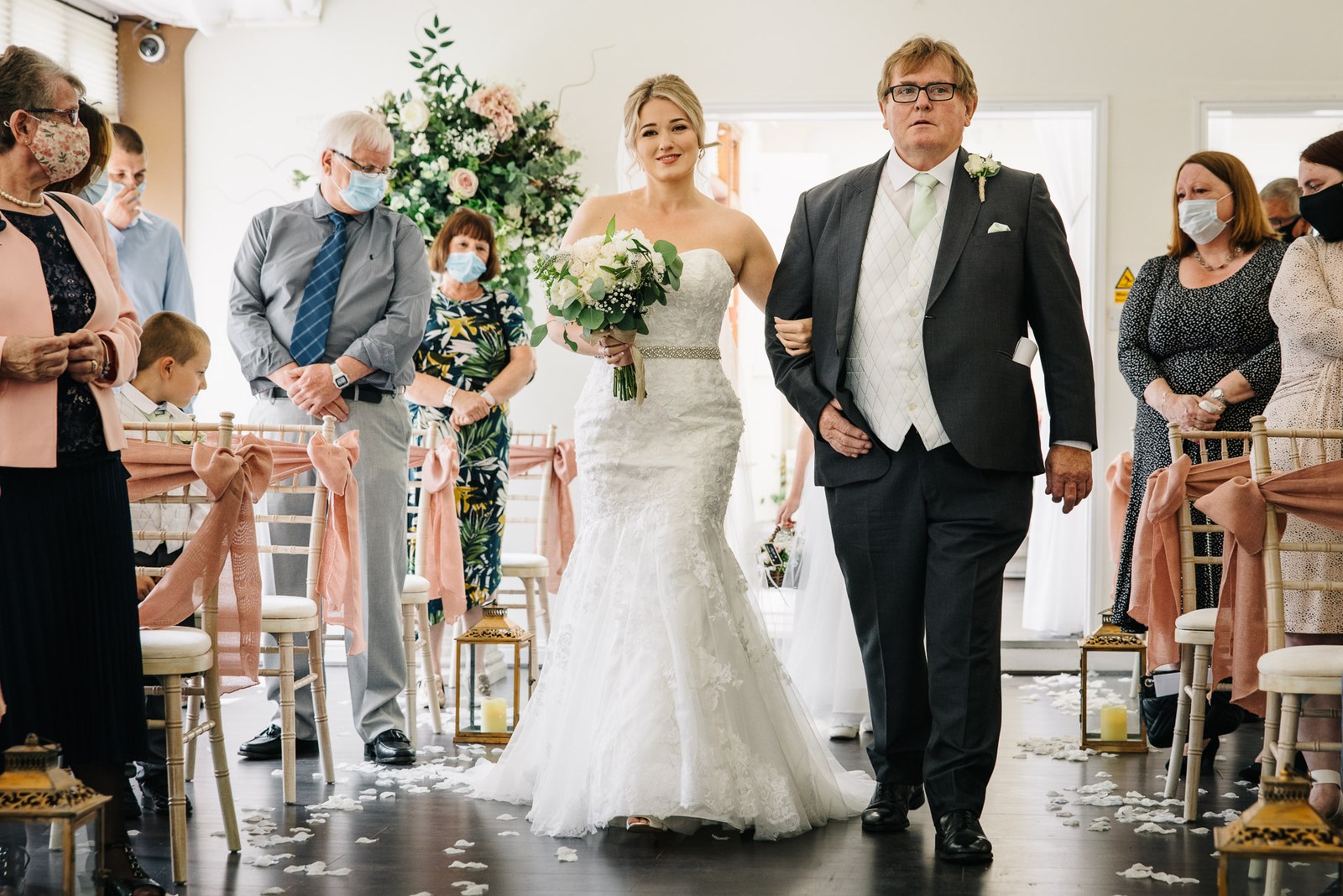 The bride walking down the petal aisle on her father's arm at Steventon House Hotel