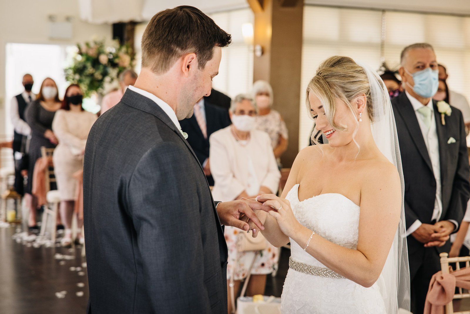 Close view of the bride sliding the ring onto the groom's finger