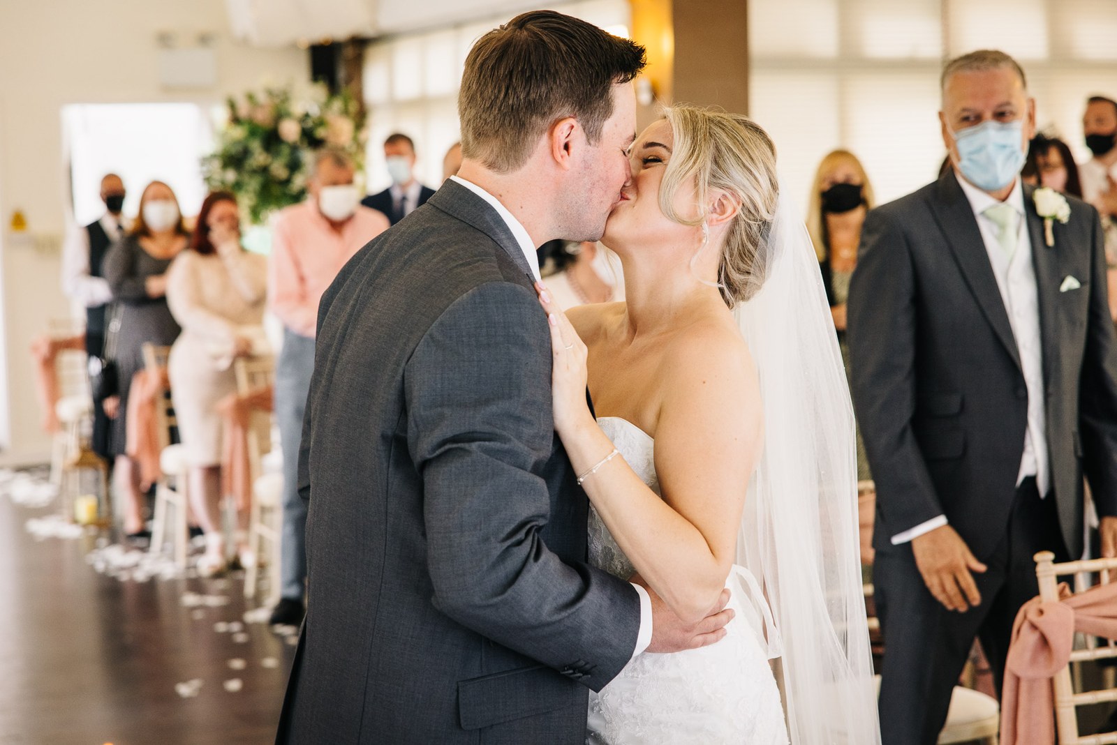 Bride and groom sharing their first kiss as newlyweds
