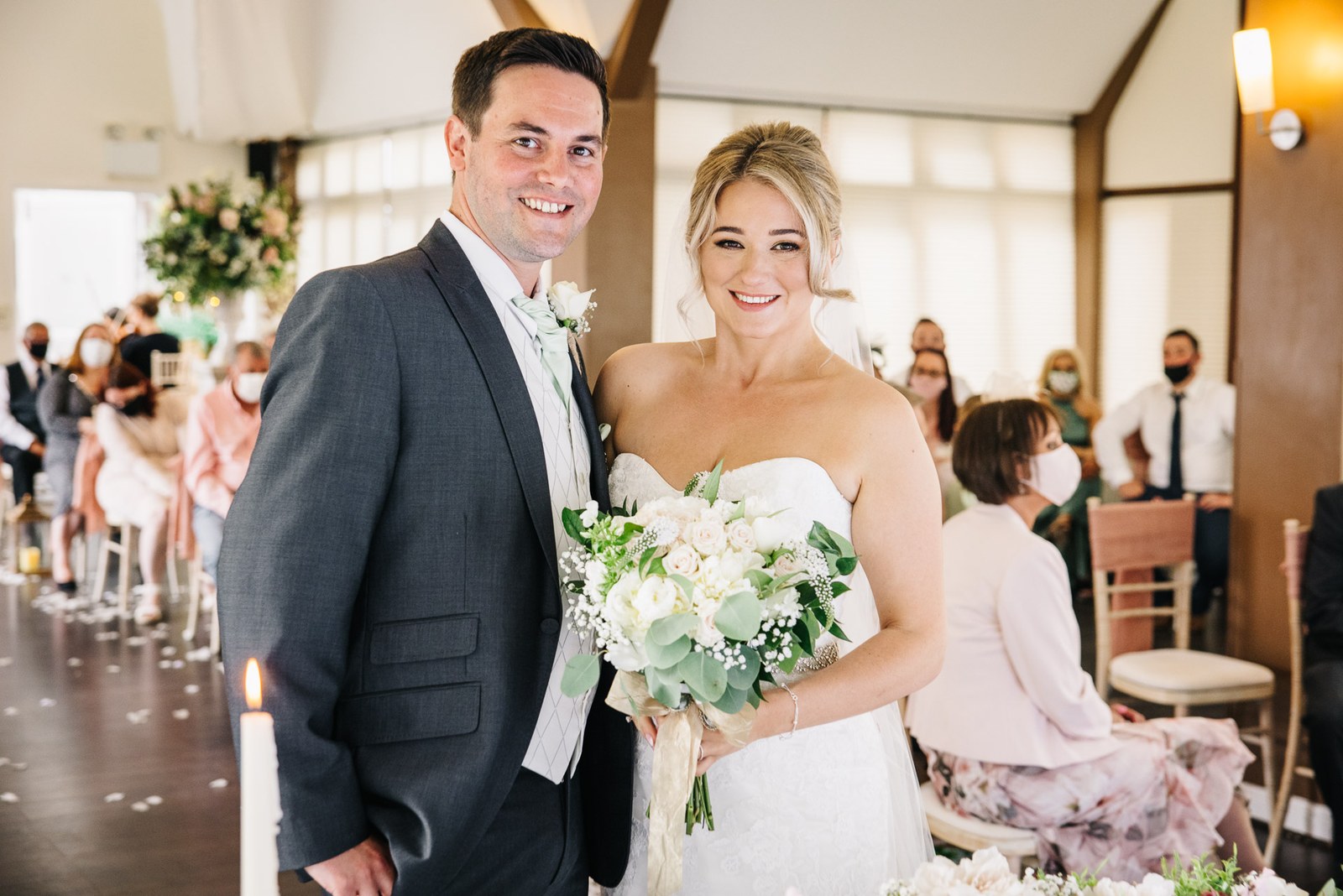 Bride and groom together indoors after the ceremony, bouquet in hand
